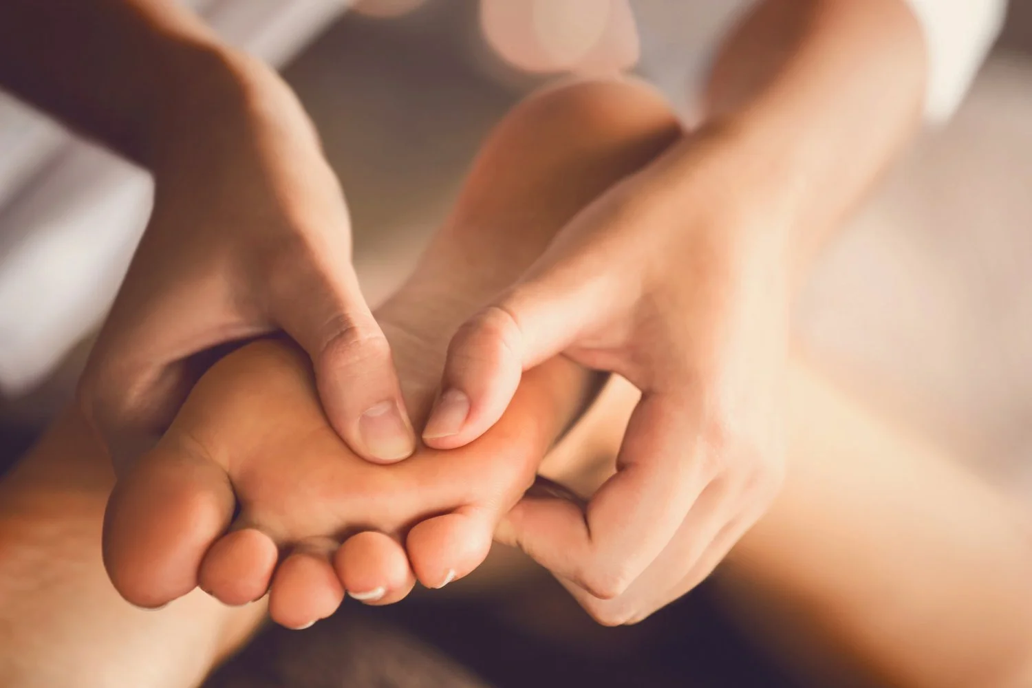 Close-up of adult hand massaging a foot with a gentle grip