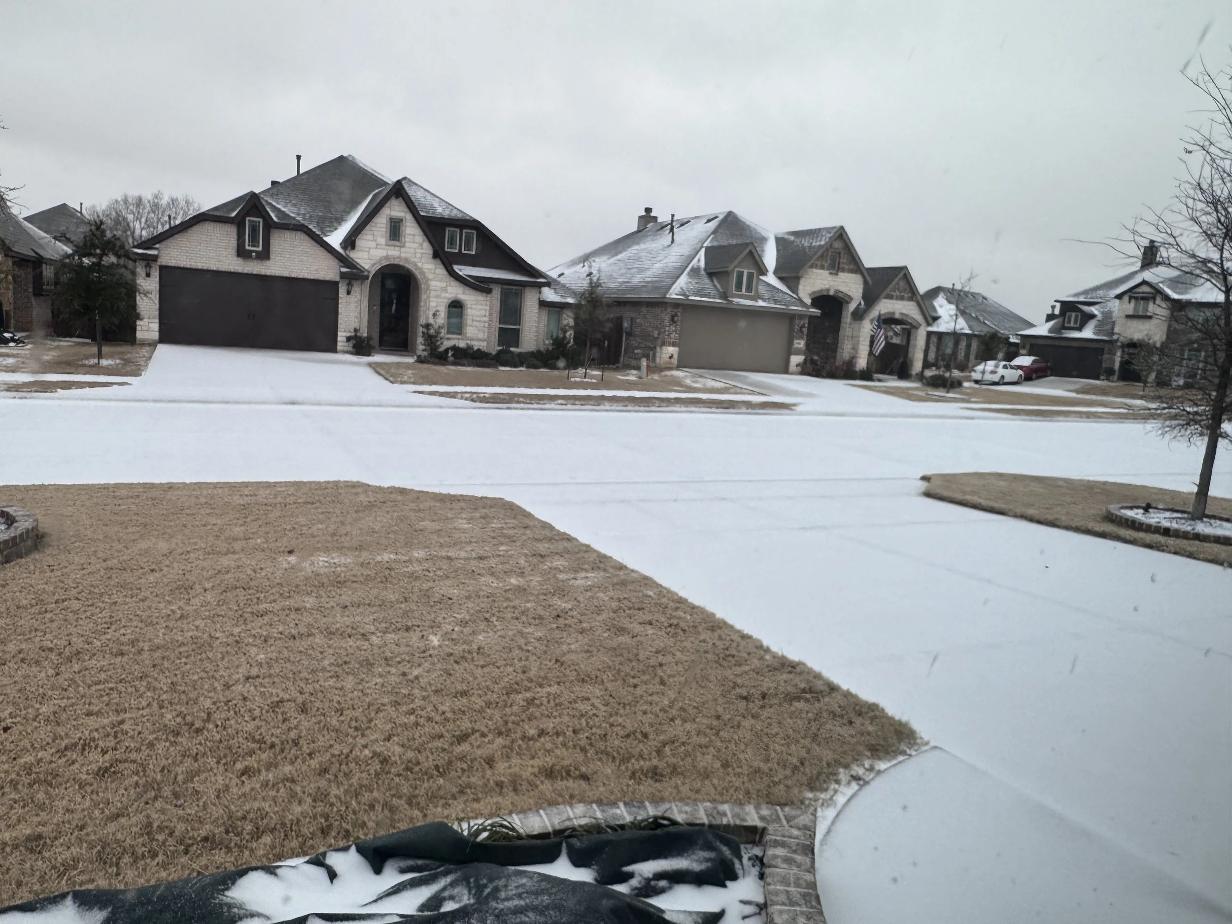 View outside window of homes with snow and sleet in Texas