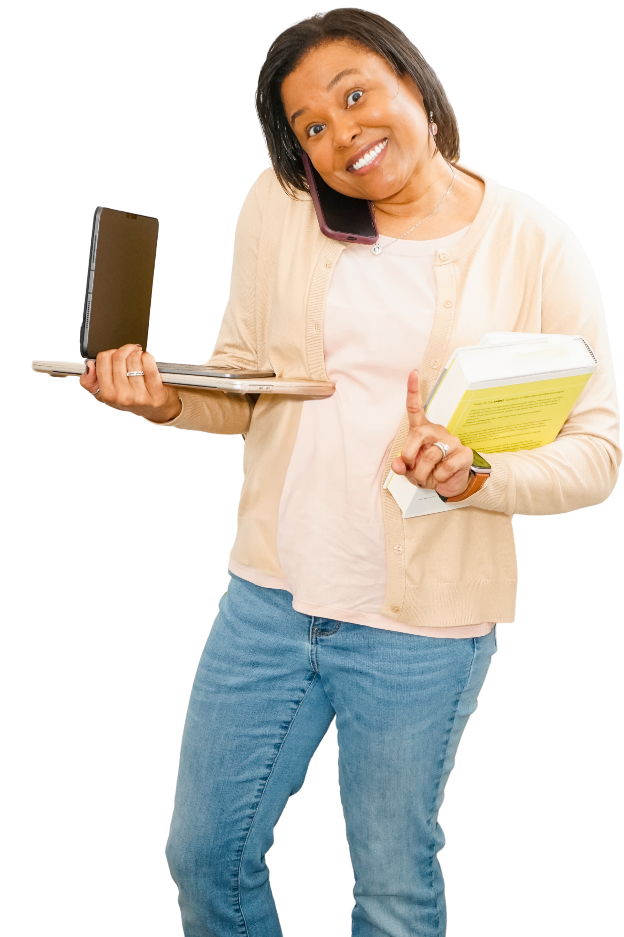 Woman holding laptop and books while holding one figure up to say "one minute"