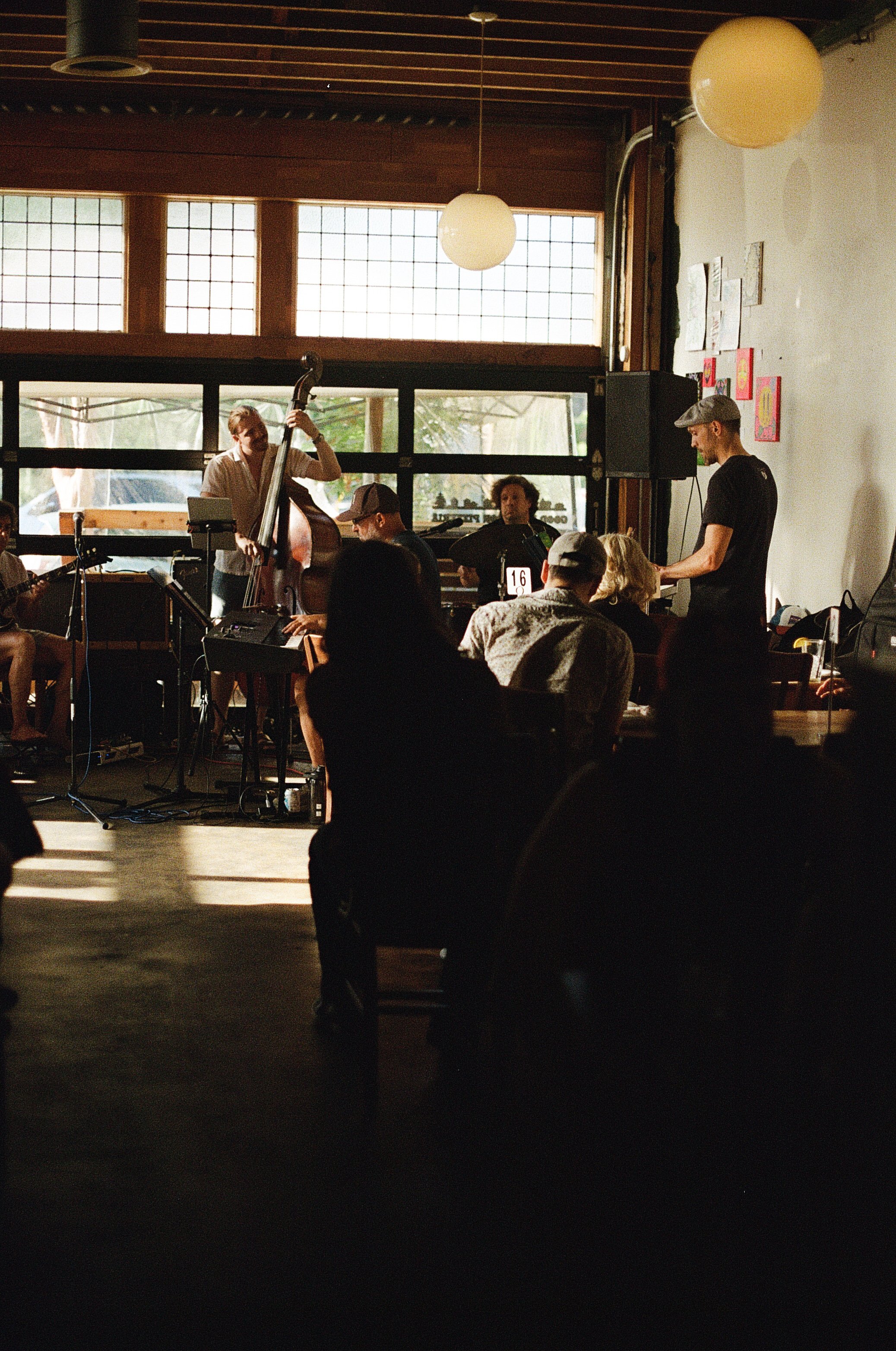 Todd Marston playing keyboard with a group of jazz musicians in a brightly lit music venue