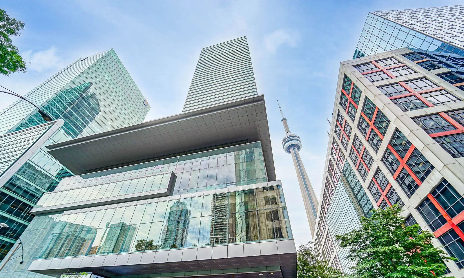 View of tall modern skyscrapers and the CN Tower in downtown Toronto, Canada, from a low angle during daytime.