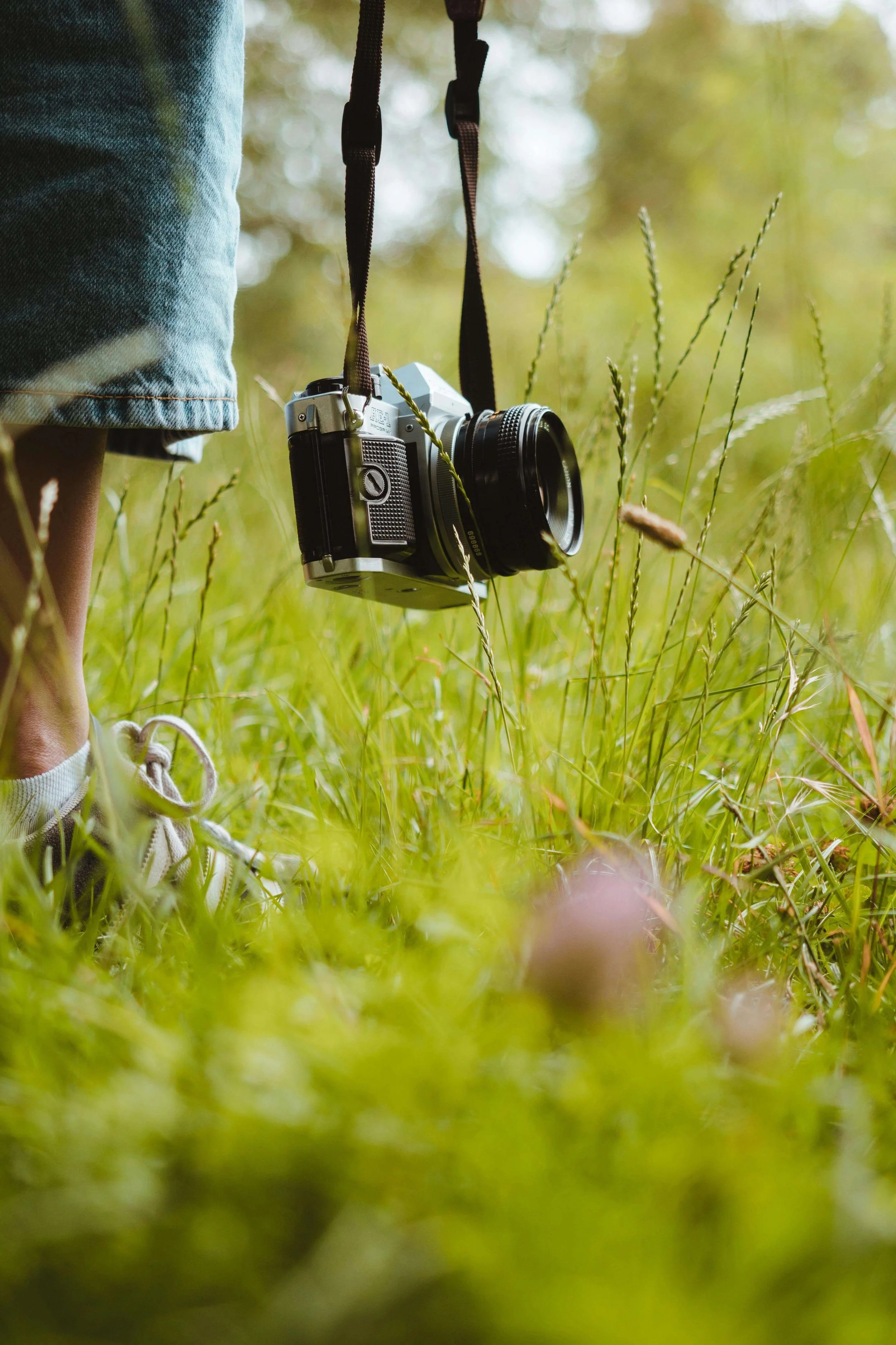 A close-up of an individual holding a camera strap outside near green grass. An OCD therapist in Boston, MA can help you figure out a support plan if self-care isn't enough. Reach out today for therapy.