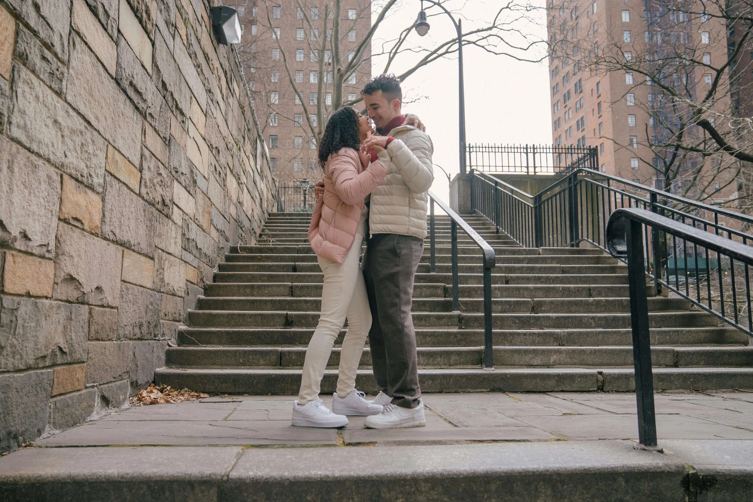 A biracial couple dancing together on city concrete stairs. Representing how OCD therapy in Boston, MA can help you navigate anxiety around love & relationships. Get started today.