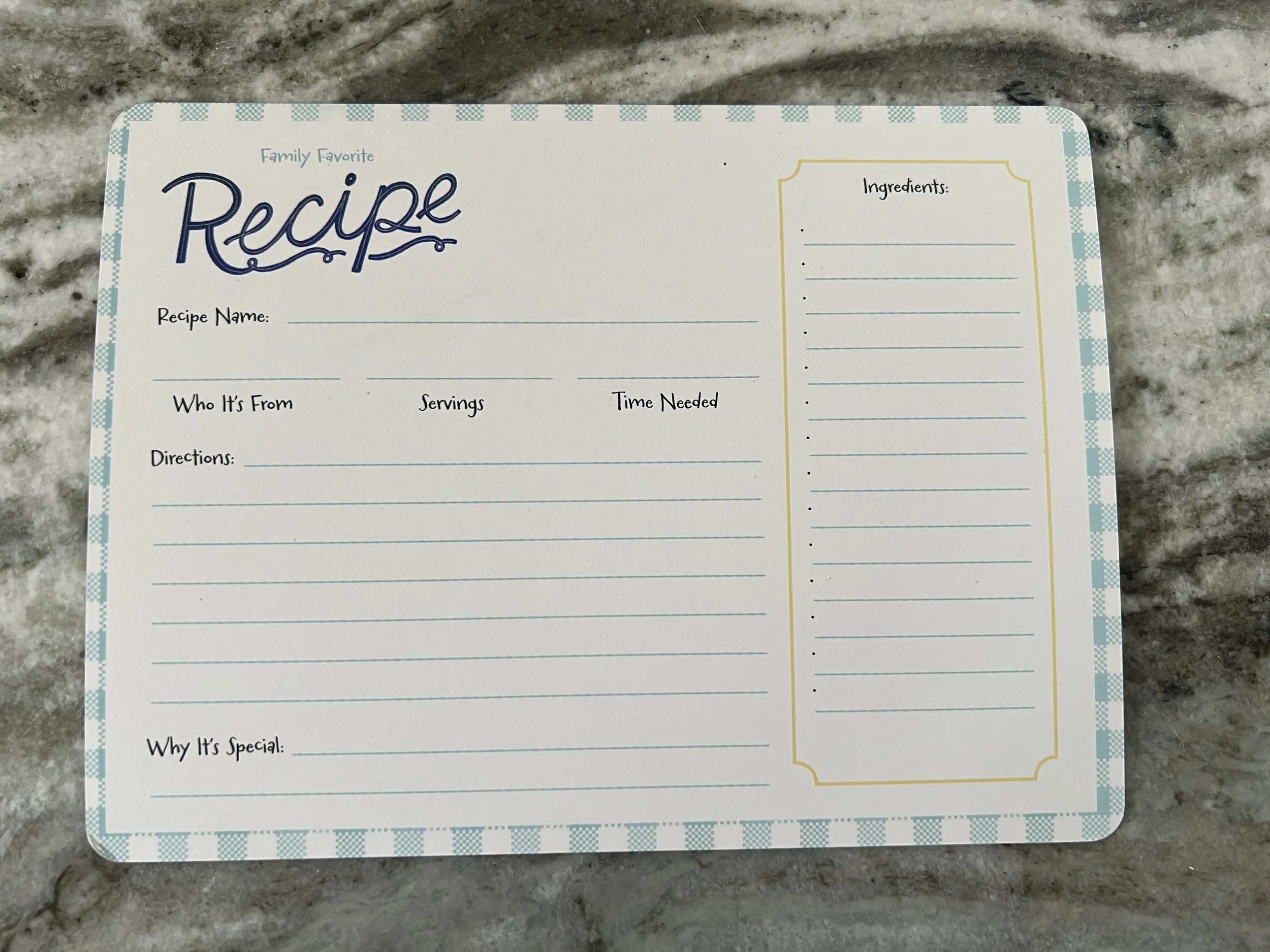 Blank recipe card with sections for ingredients, directions, and other details on a marble countertop.