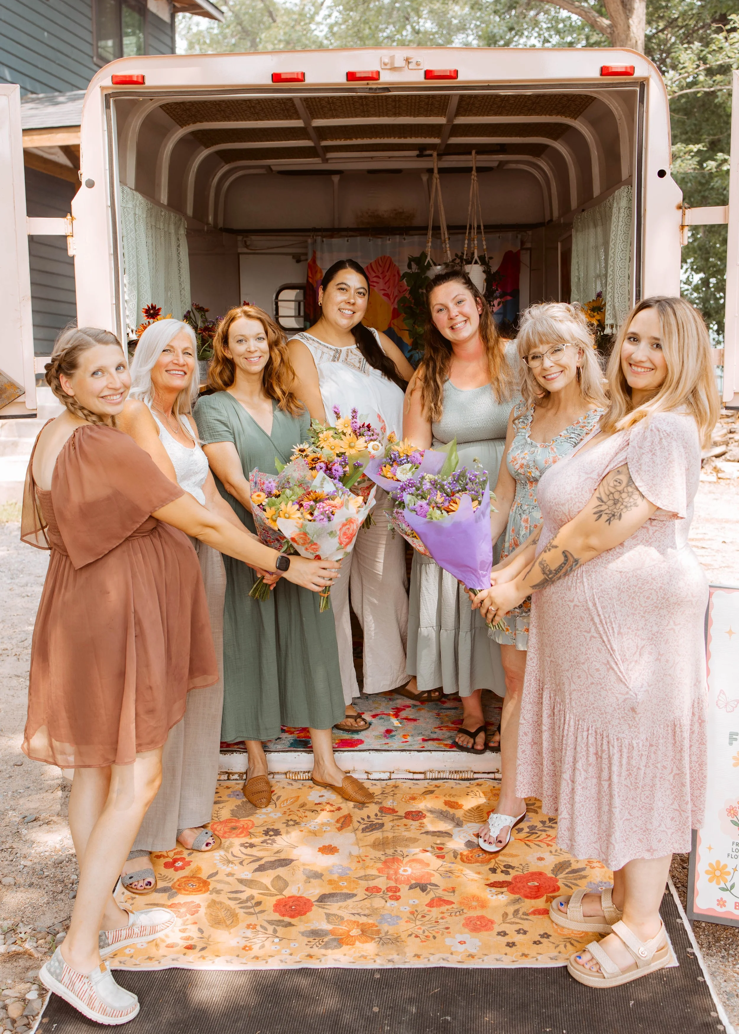 Seven Ladies Dressed Up In trailer With Flower Bouquets Outside