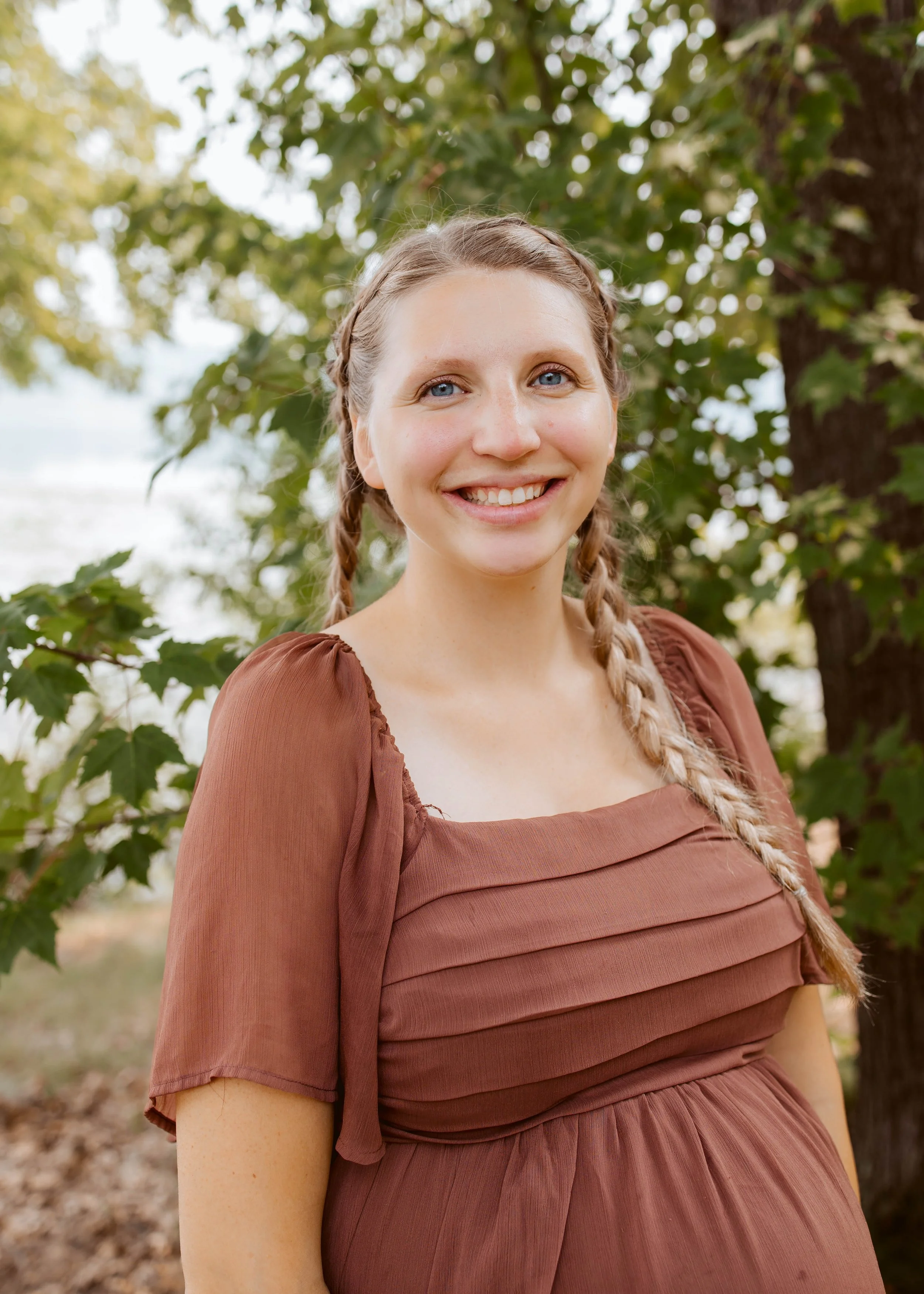 Pregnant Woman Smiling Outside With Trees
