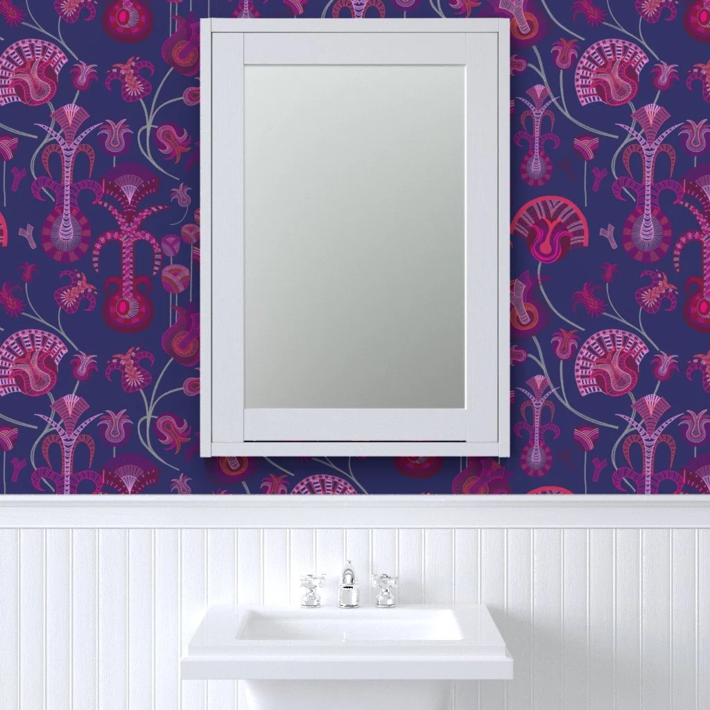 Layered tulip-like forms with intricate detail play across the vibrant blue wallpaper set behind a bright white vanity, mirror and wainscotting.