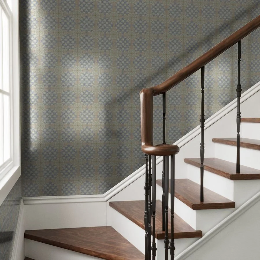 decorative silver-toned wallpaper with compass rose and fish scale repeating motif on wall behind a hardwood staircase and bring window