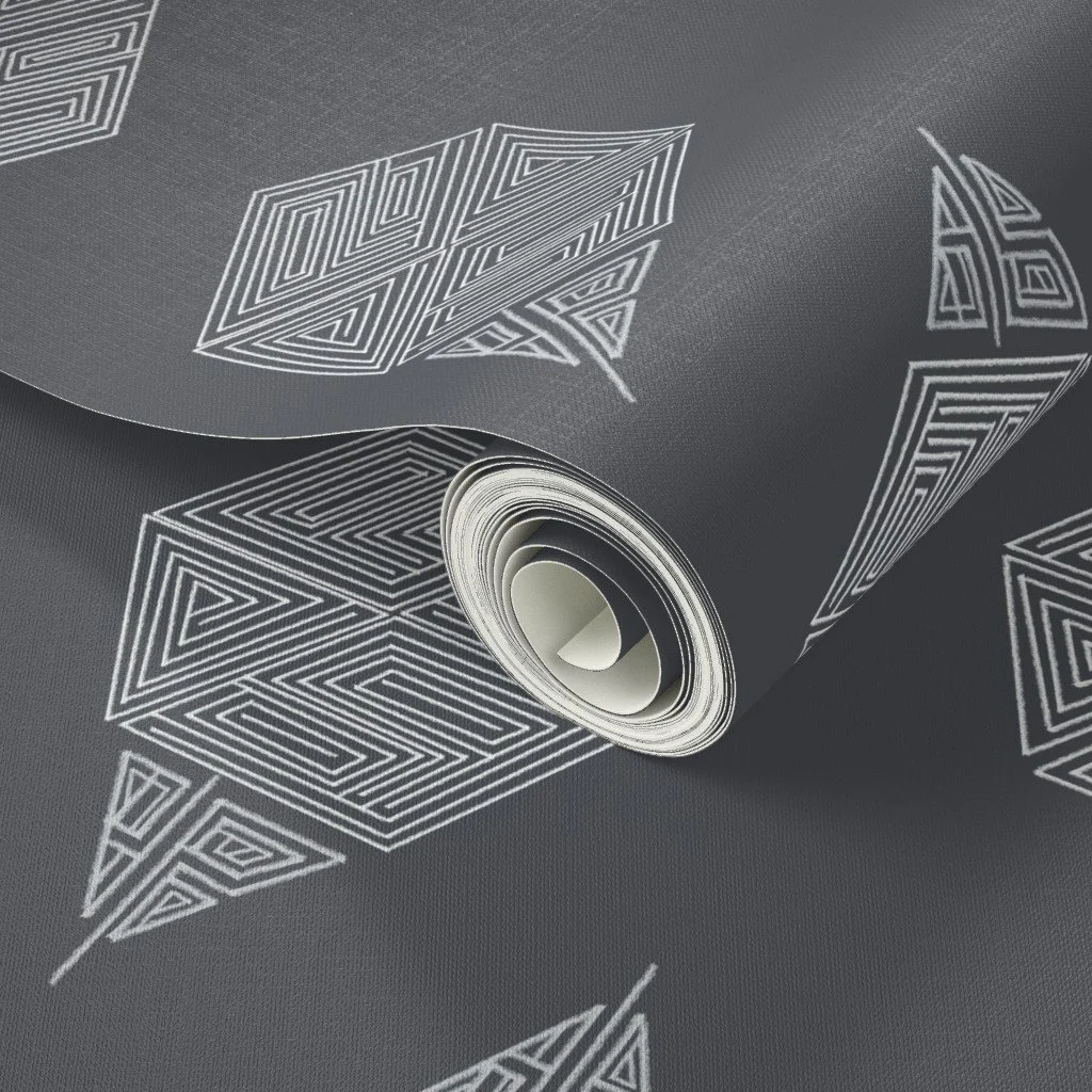 A close-up of the charcoal grey geometric wallpaper, showing the hand-drawn hexagon motif. Pale grey maze-like line work stands out against the dark charcoal ground