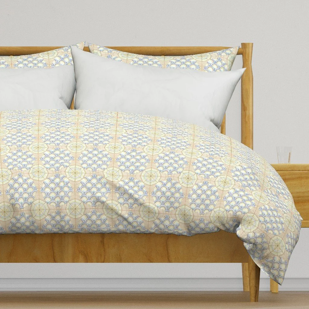 decorative fabric with compass rose and fish scale repeating motif on a duvet on top of a oak framed contemporary bed in a bright white room