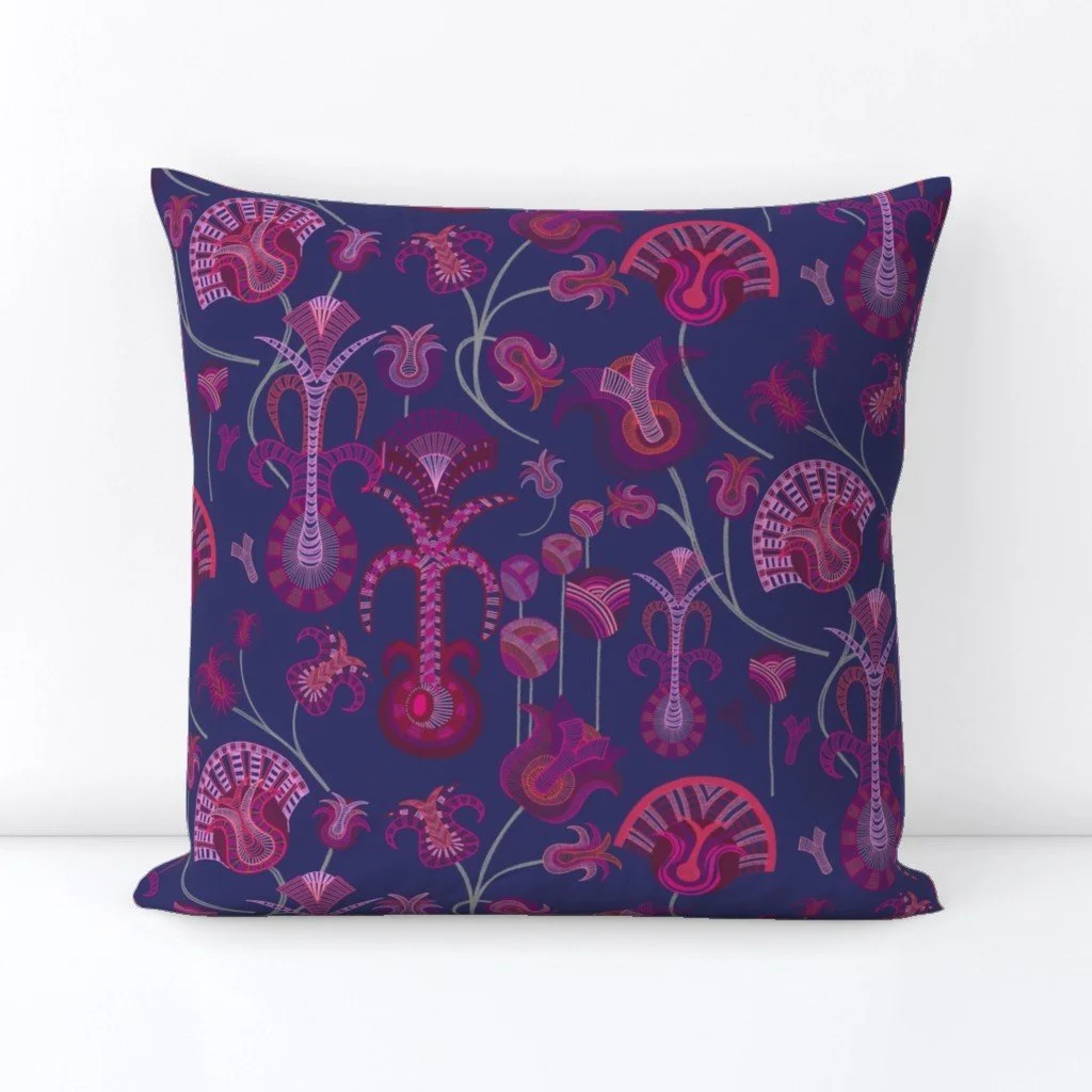 Layered tulip-like forms with intricate detail play across the vibrant blue on a square throw pillow
