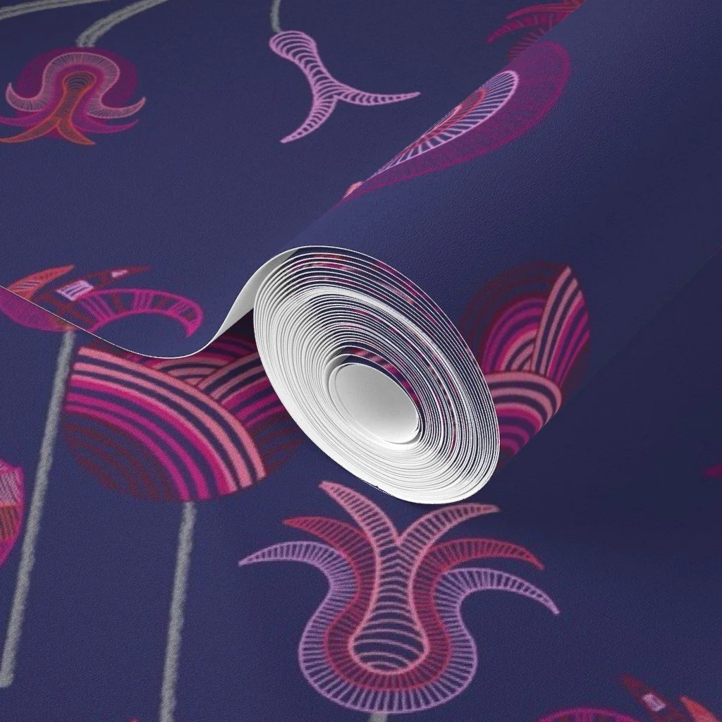 Whimsical tulips meander and sprout with detailed vibrancy against a deep blue ground on a roll of wallpaper