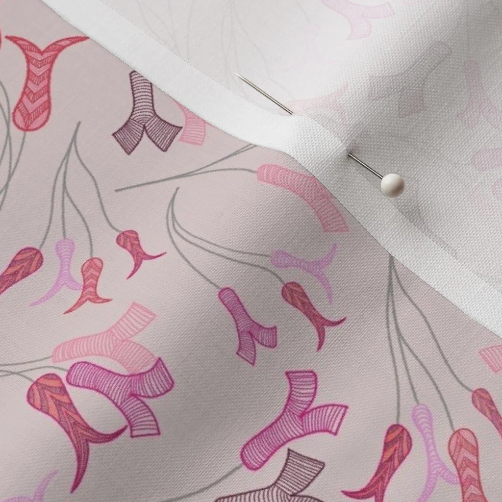 Abstract tulip stamens dance across a pale pink fabric with a dress-makers pin
