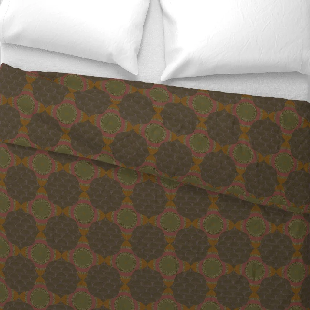 Duvey with dark brown fish scale and center star pattern on crisp white sheets next to white bed pillows