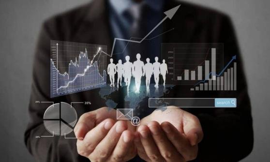 Hombre de negocios con gráficos y estadísticas flotando en un fondo digital.