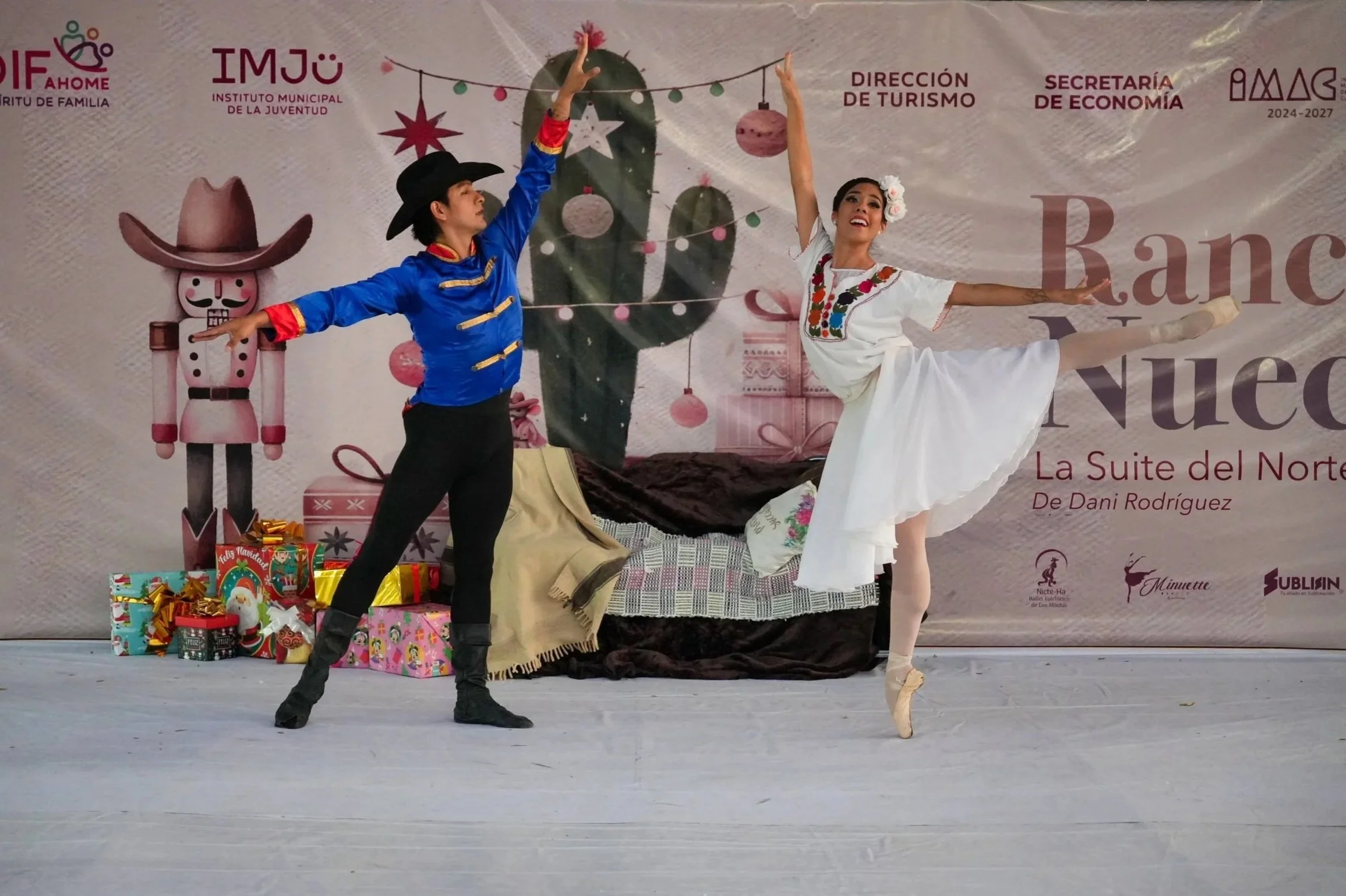 Pareja bailando ballet en escenario decorado con regalos y motivos navideños