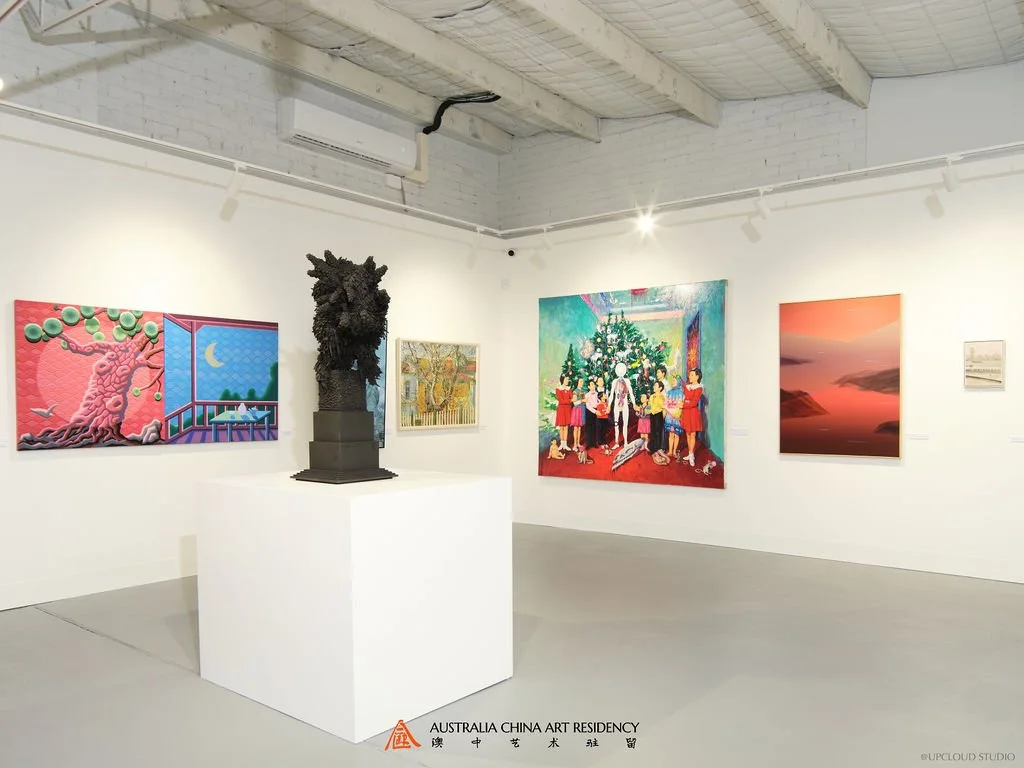 Art gallery with various paintings and a sculpture on a pedestal. The paintings include colorful abstract and landscape scenes, and a holiday-themed depiction with a Christmas tree and children.