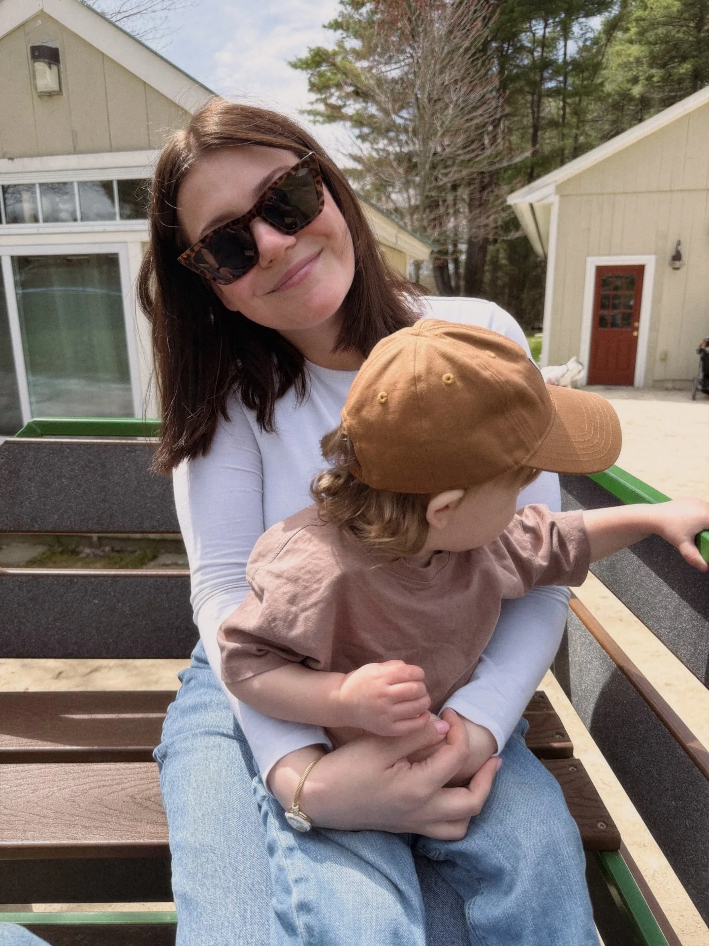 Allison sitting outdoors and holding her young child.