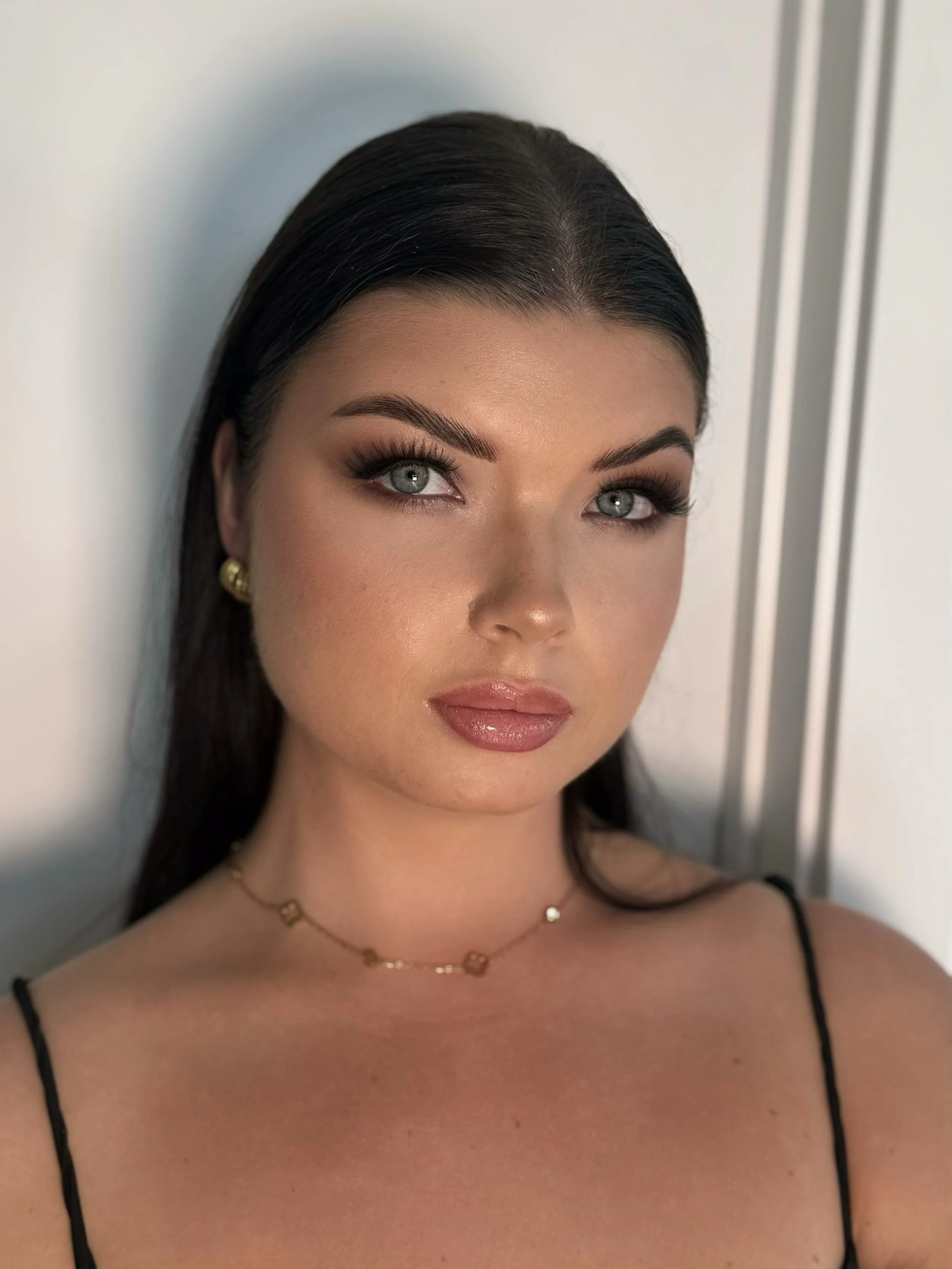 Close-up of bridesmaid with soft smoky eye makeup getting ready.