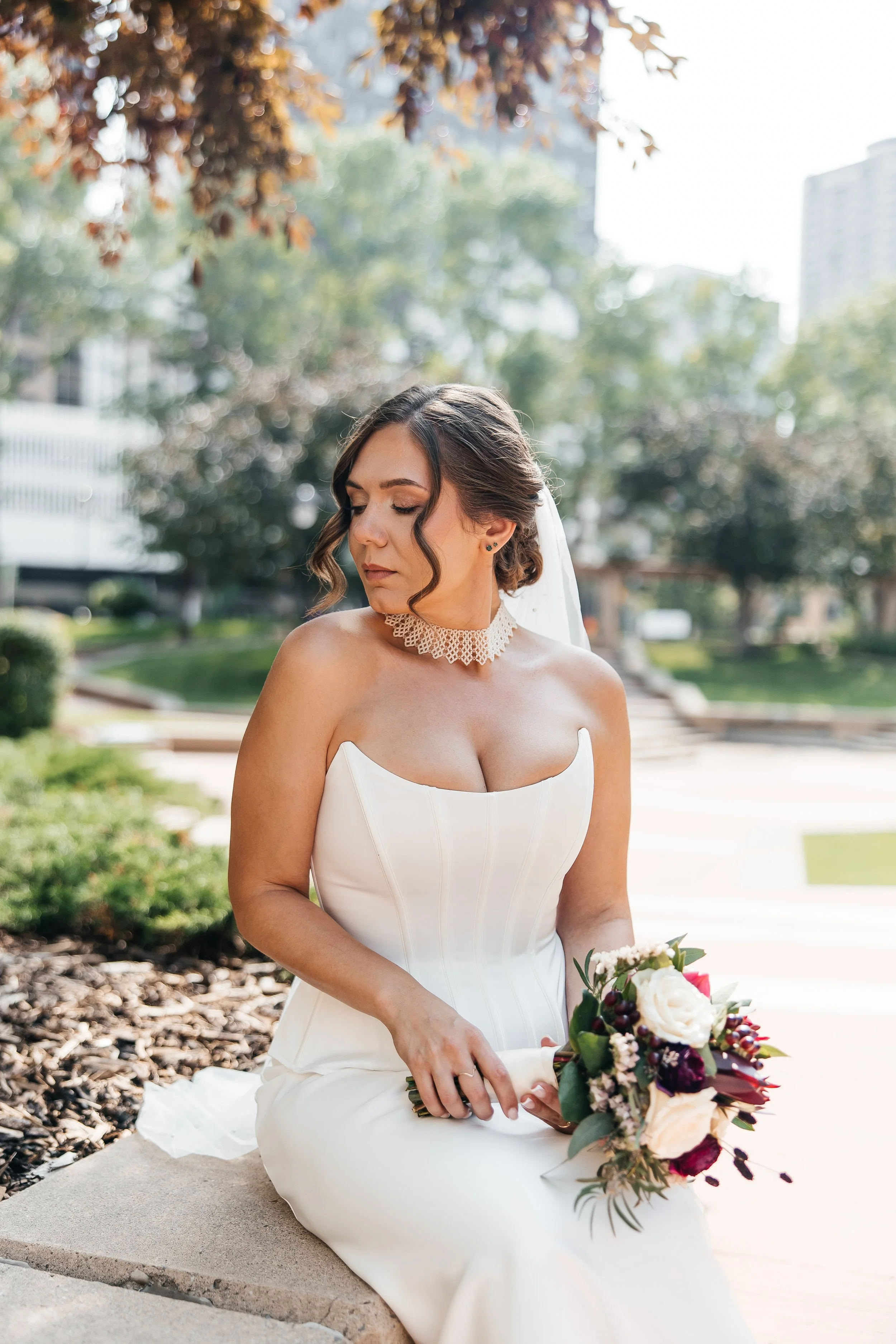 Bride in a corset gown with a soft glam updo and veil before the ceremony