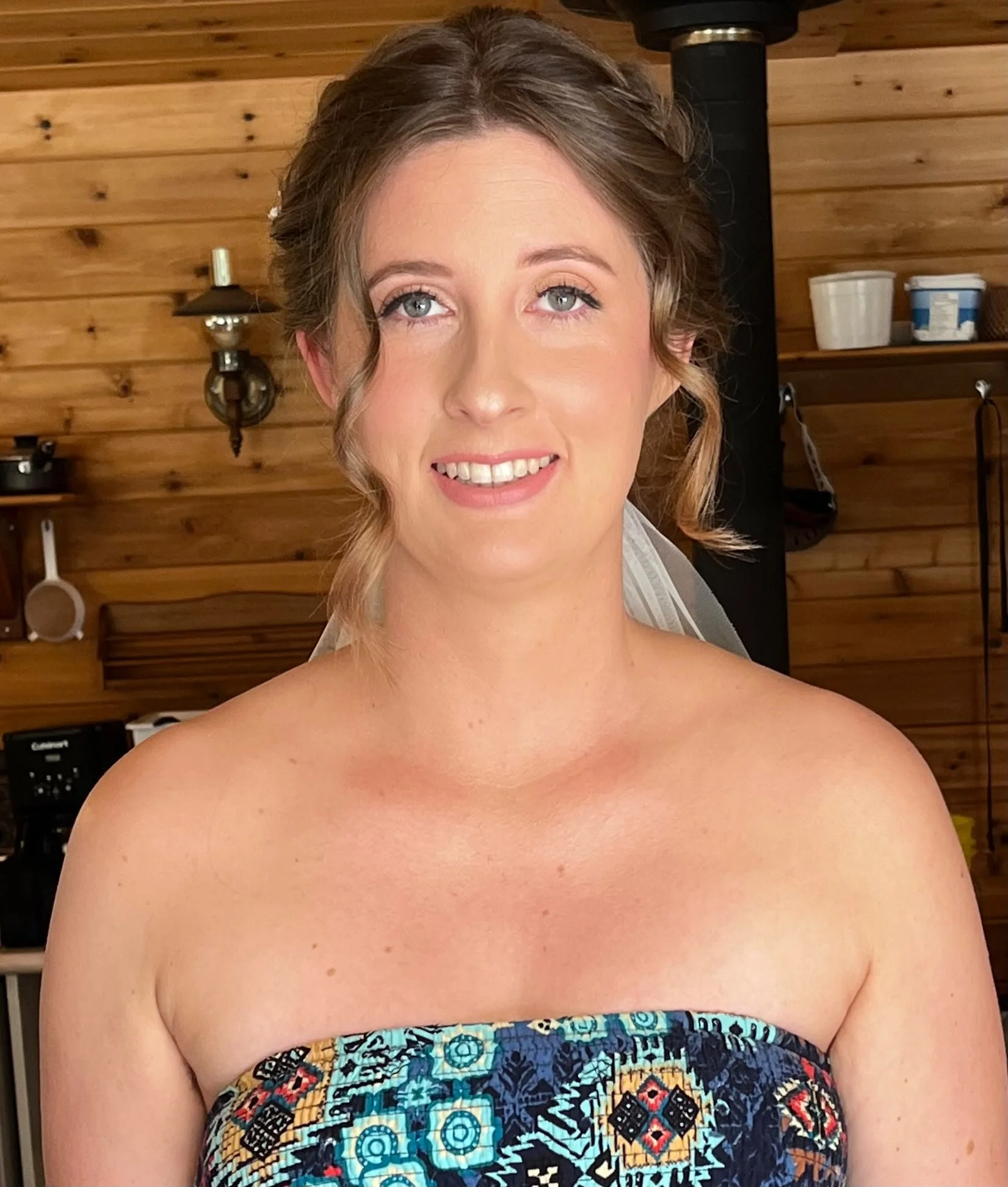 Smiling bride featuring a classic bridal updo and soft romantic makeup by North of Blush mobile beauty team, serving Calgary, Airdrie, and Cochrane.