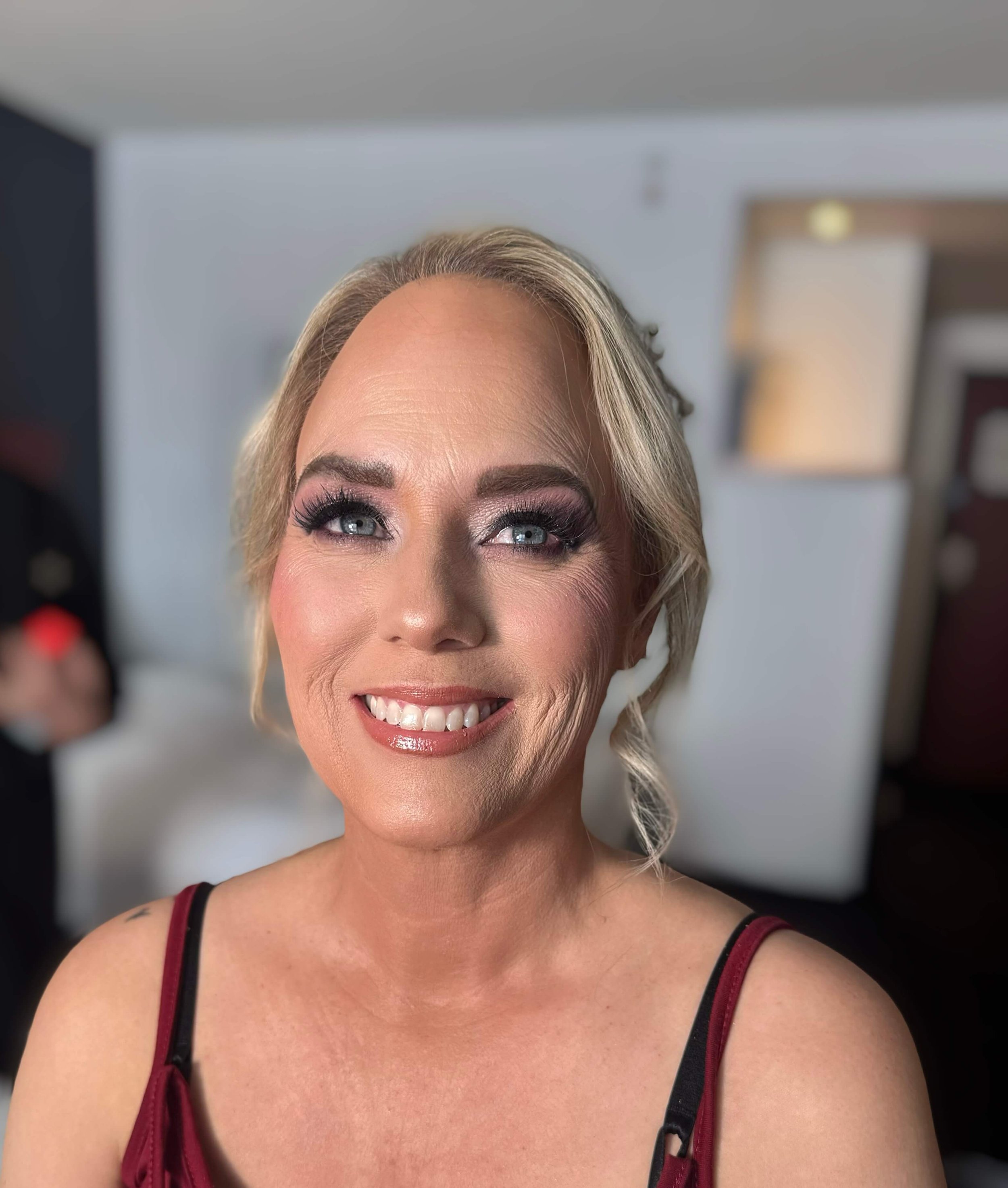 Soft glam makeup with smooth, even skin, defined brows, smoky eye makeup with long lashes, rosy blush, and glossy nude-pink lips