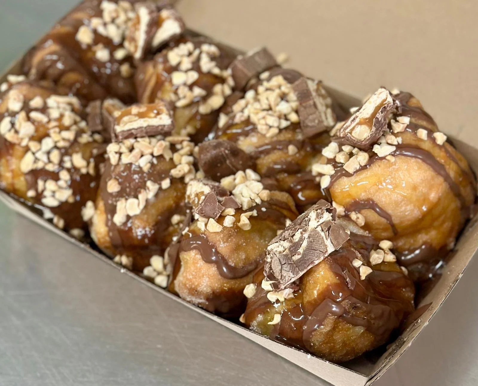 Jessie's Pizza Box of donuts topped with chocolate, chopped almonds, and chocolate chunks. best pizza in Point Cook