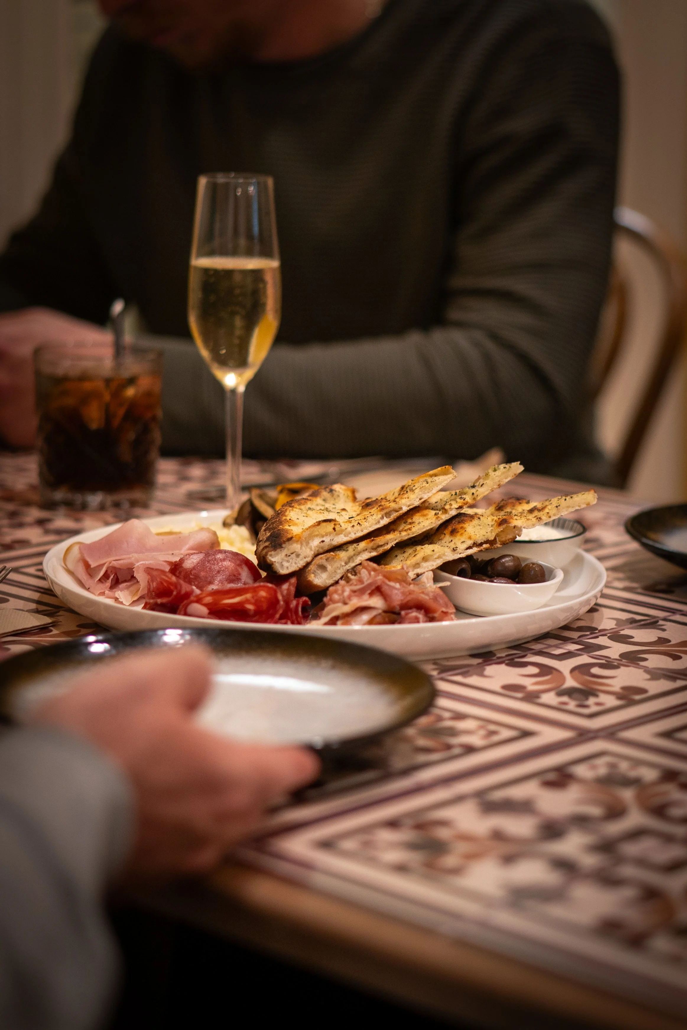 Salumi board entree with cold meats, Italian cheeses, olives, and homemade focaccia.
