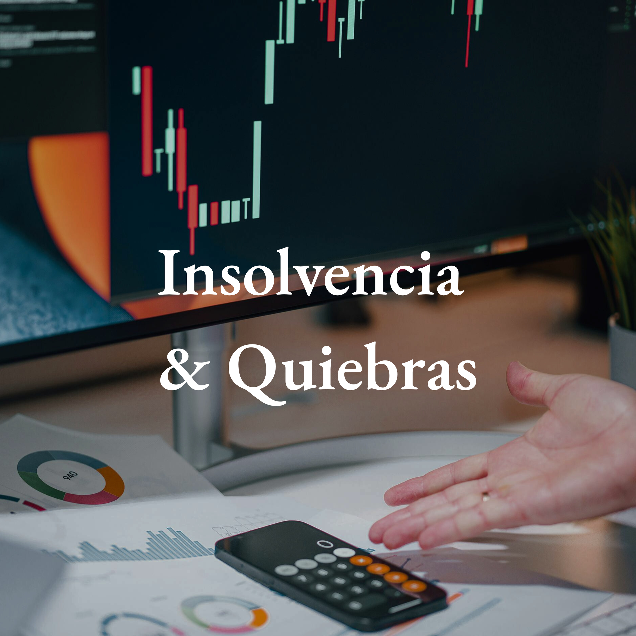 Pantalla de computadora con gráficos financieros en rojo y verde. Manos sobre documentos con gráficos, una calculadora y un teléfono móvil en un escritorio.