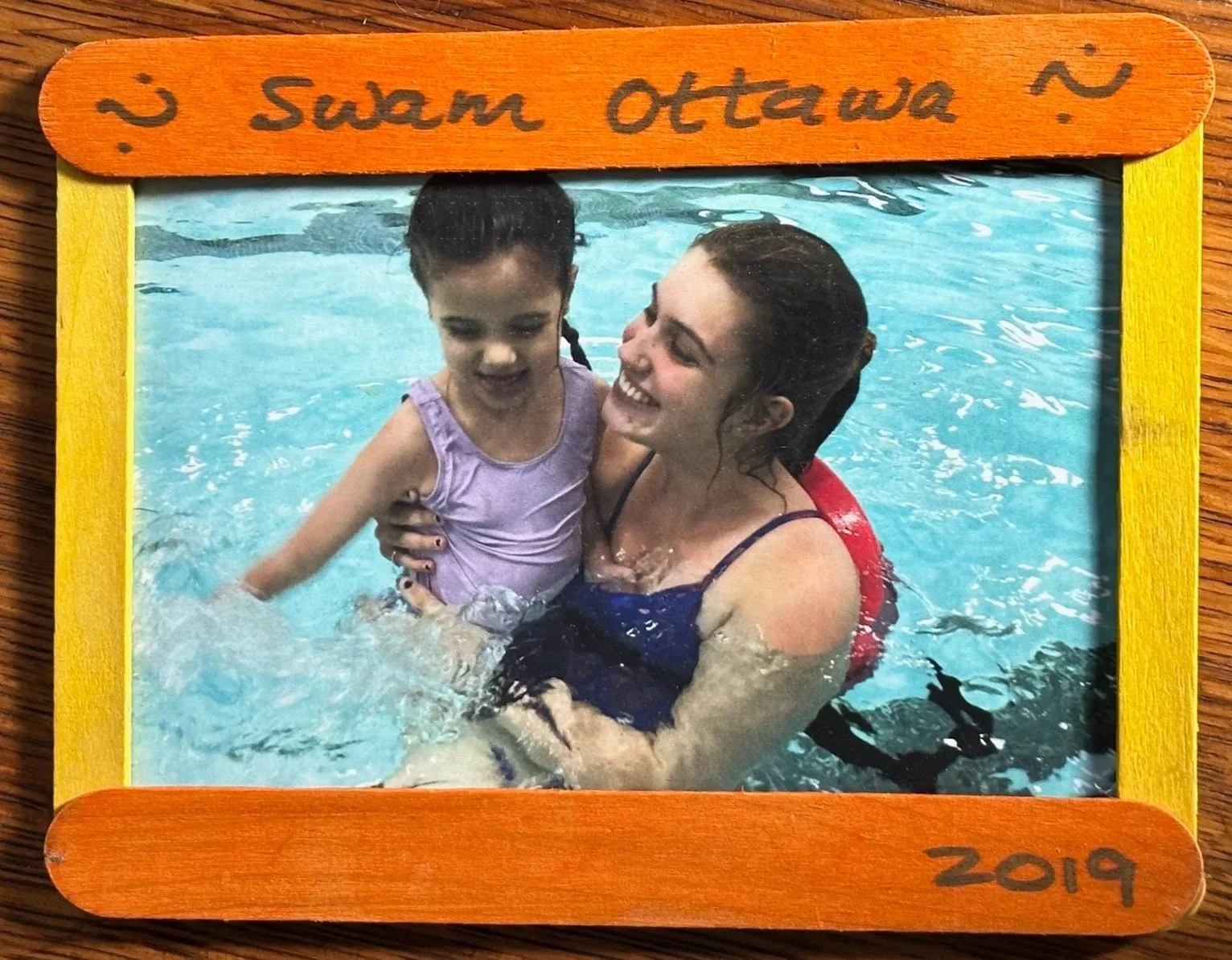 SWAM instructor and swimmer smiling together in the water. text on frame says SWAM Ottawa 2019