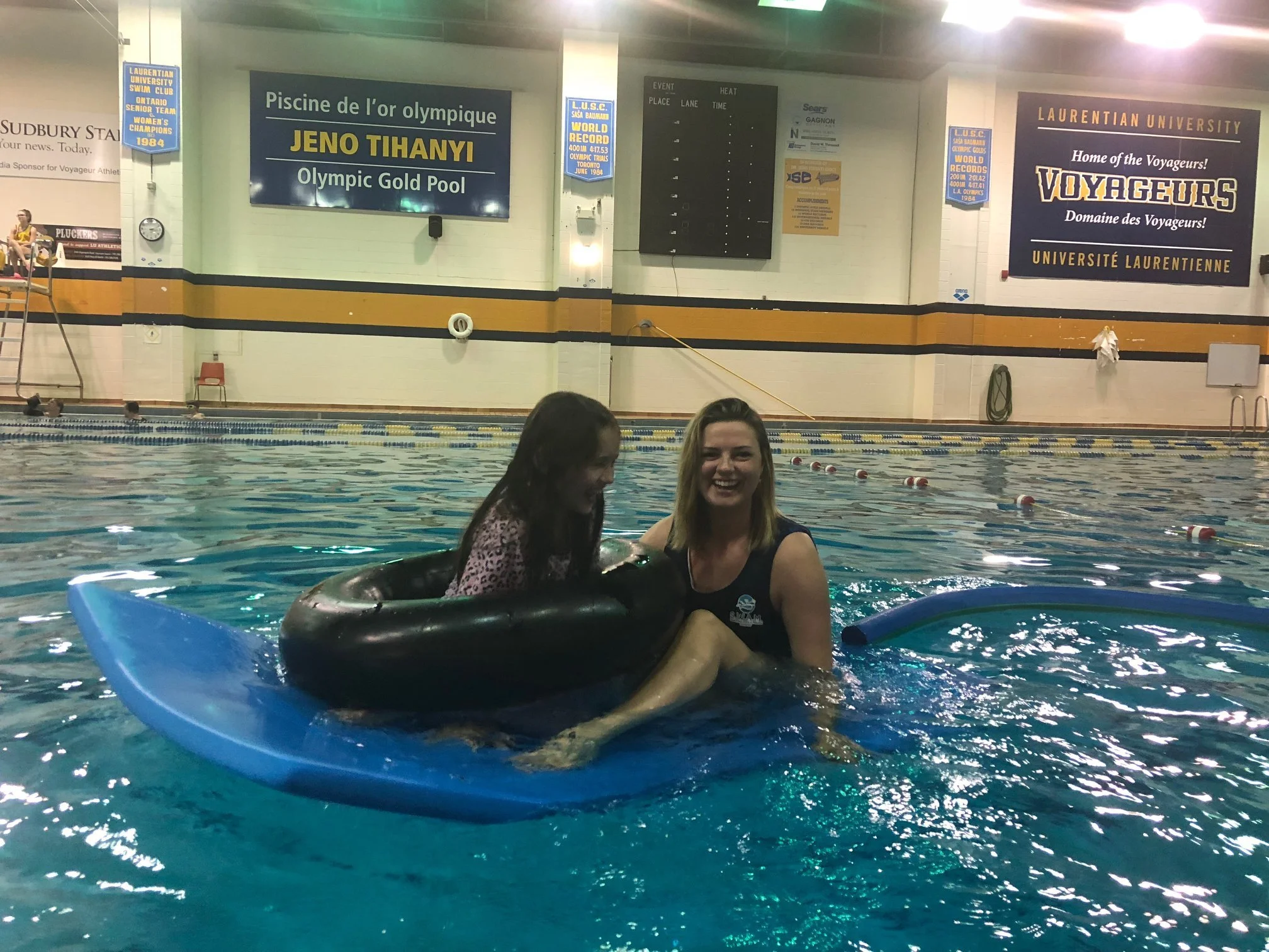 SWAM swimmer and instructor smiling on a floating mat