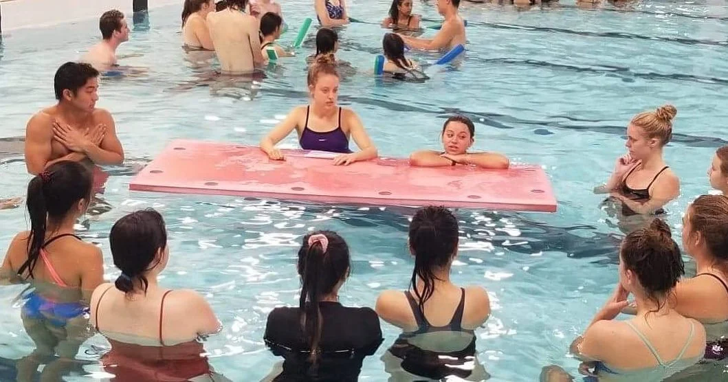 instructors standing in a circle in the water during a training session