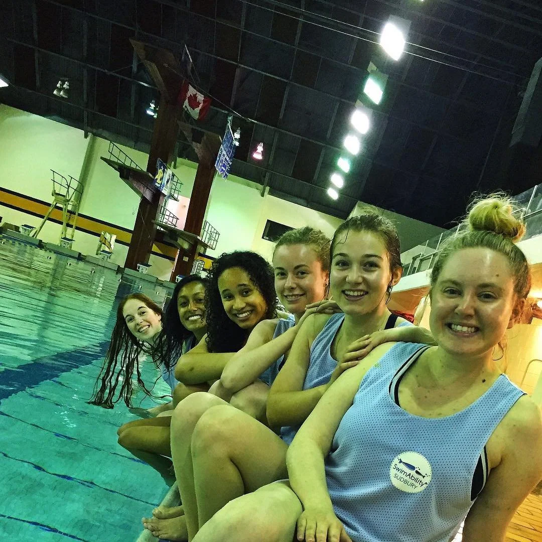 group of SWAM Sudbury instructors lined up on the pool edge, smiling