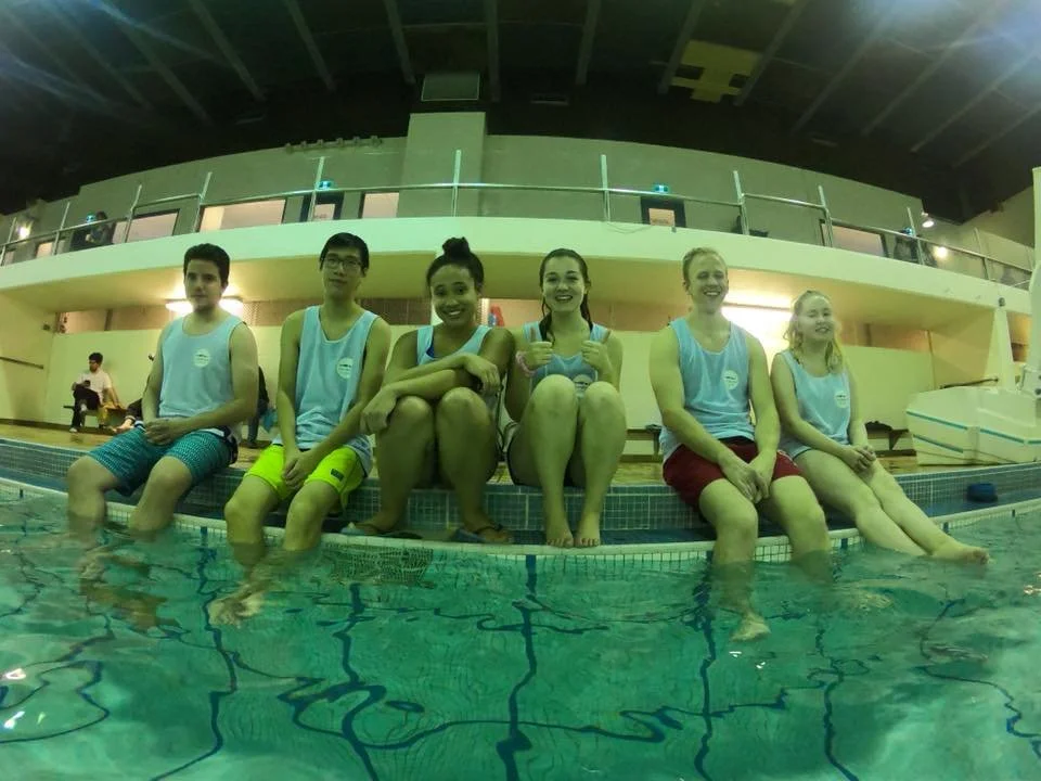 volunteers smiling with feet in the water
