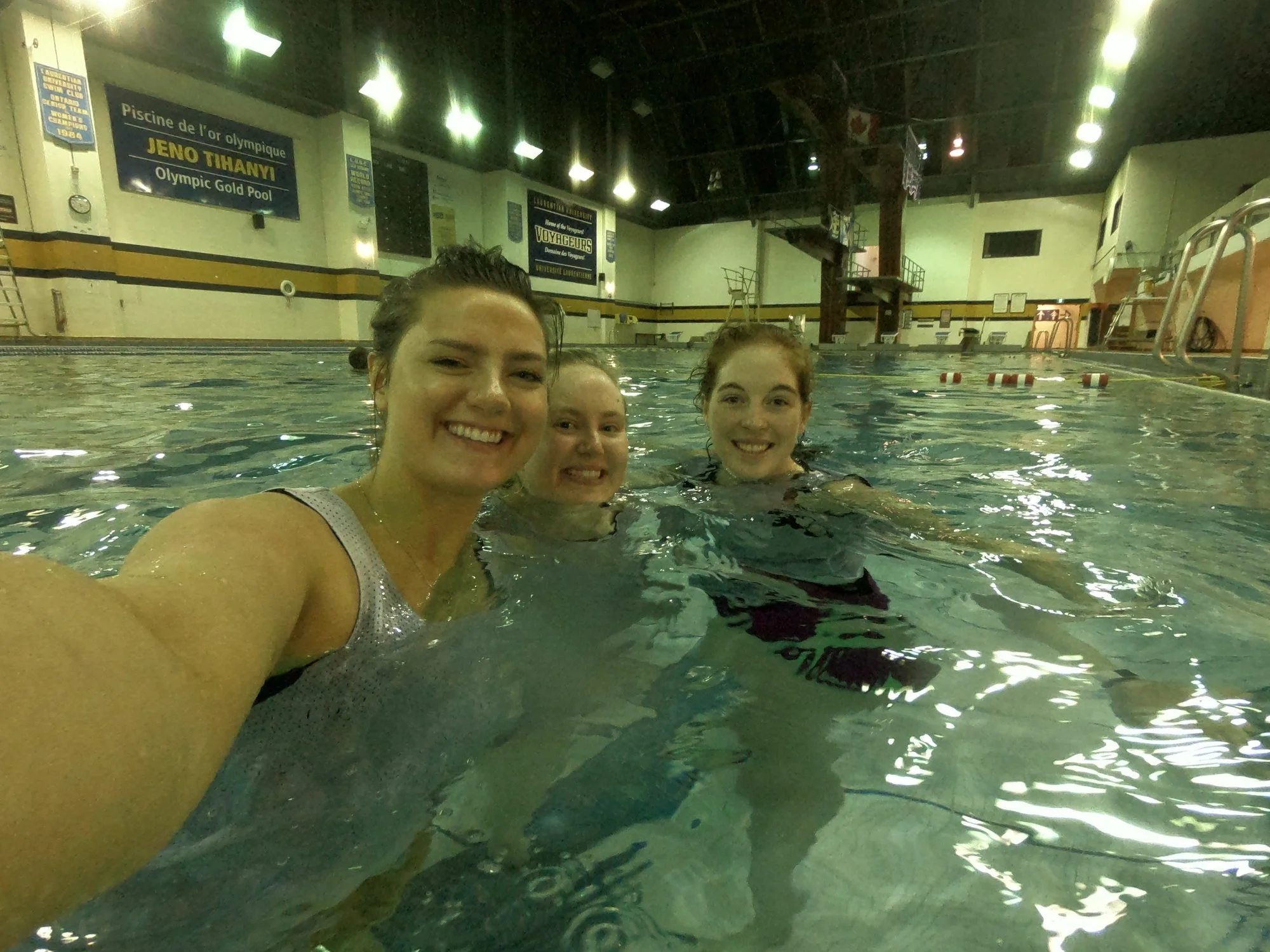 three volunteers smiling in the water