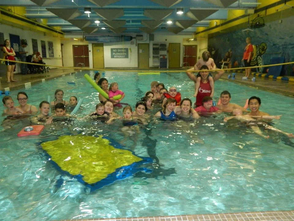 group of SWAM Ottawa swimmers and instructors smiling at the camera