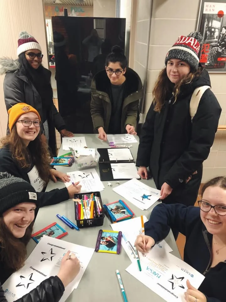 SWAM Ottawa volunteers smiling and making certificates for their swimmers