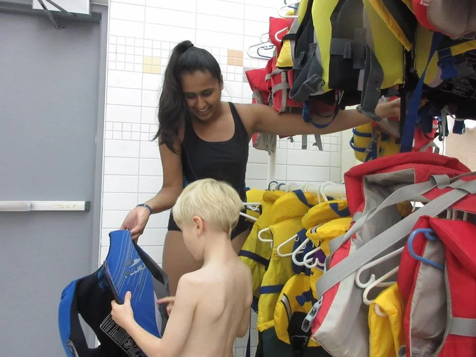 SWAM volunteer helping swimmer choose a suitable lifejacket