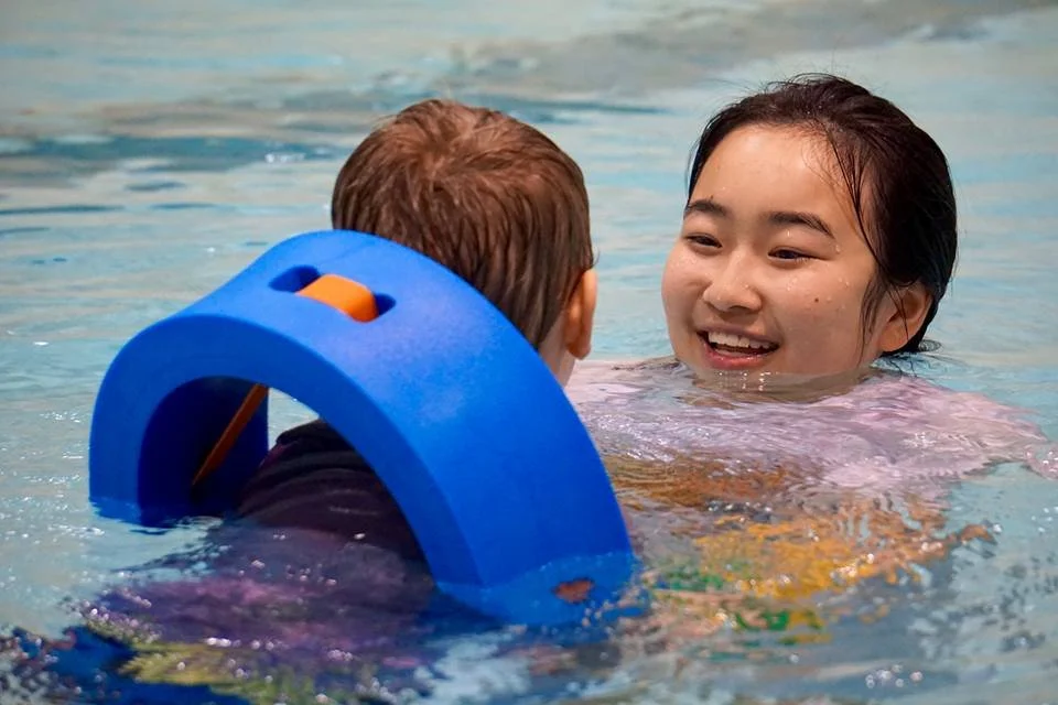 SWAM instructor smiling at swimmer, in the water