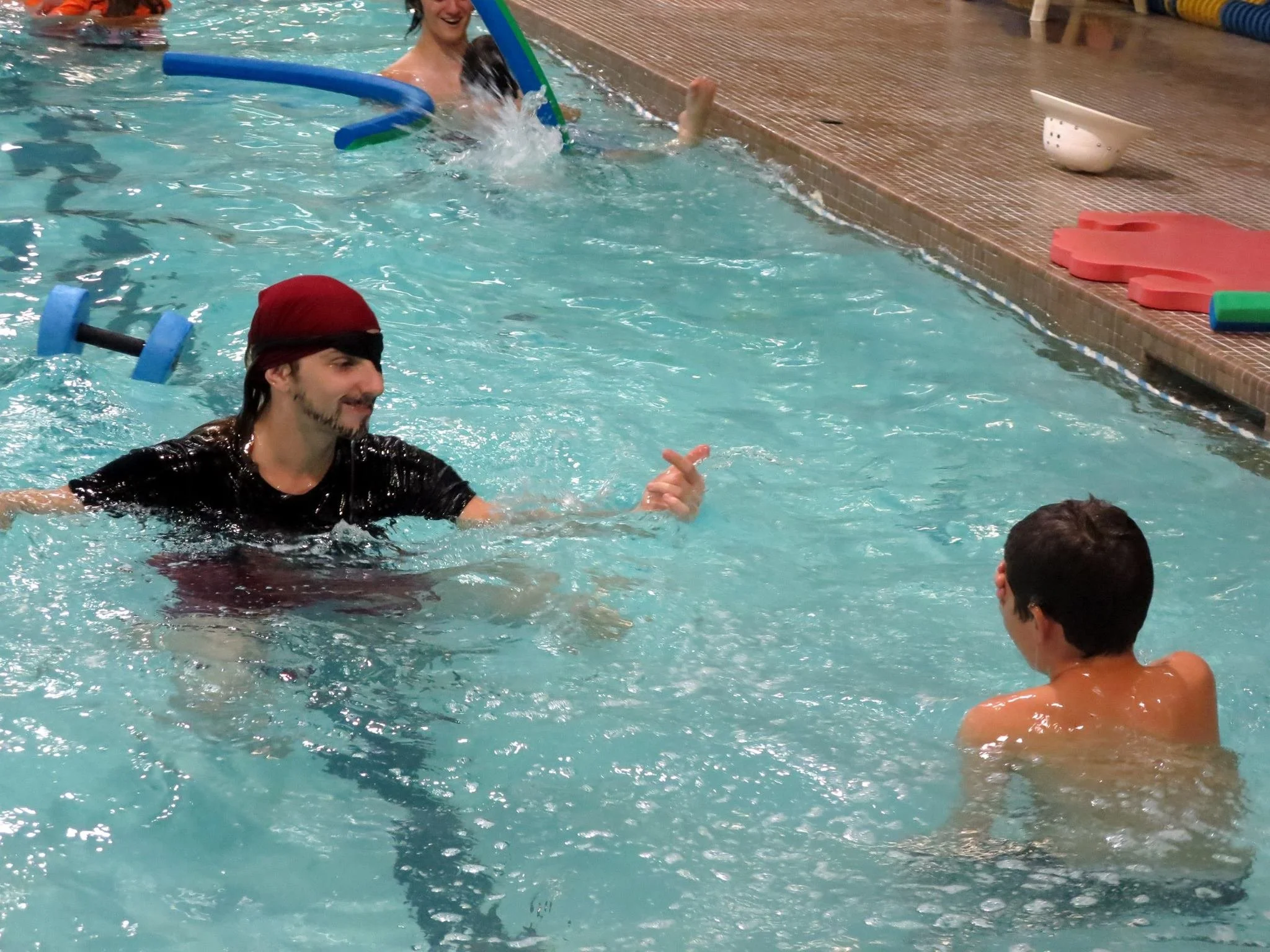 instructor dressed as a pirate, smiling at swimmer