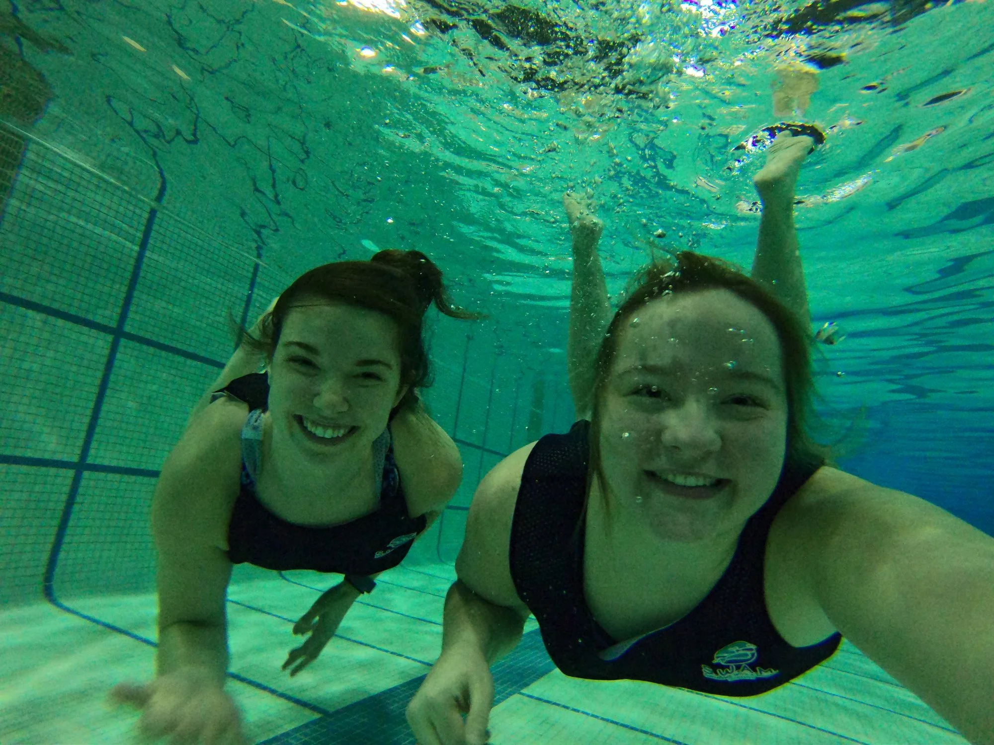 volunteers smiling and taking a selfie underwater