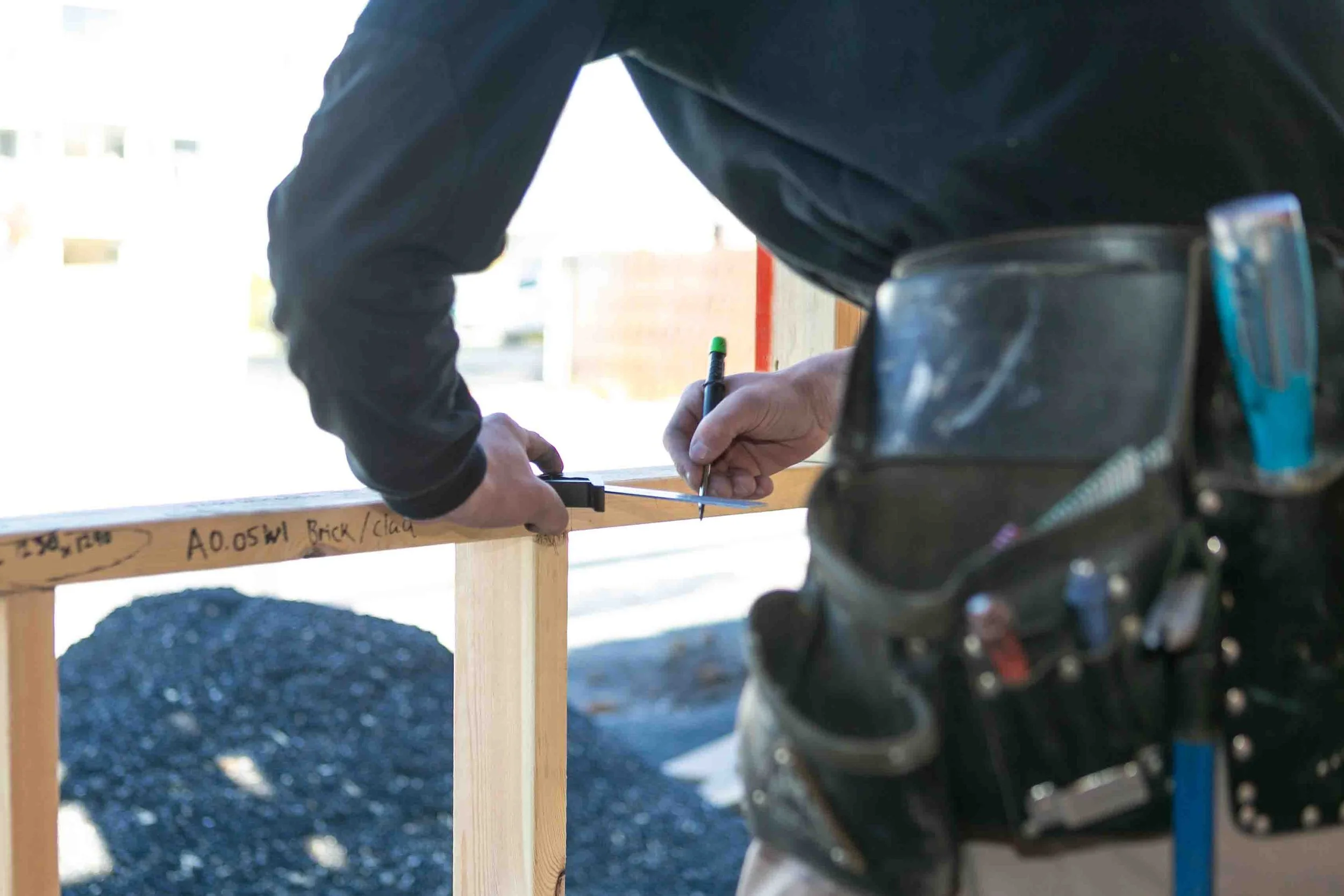A builder from MCC Projects team taking measurements for a build in Devonport, Tasmania.