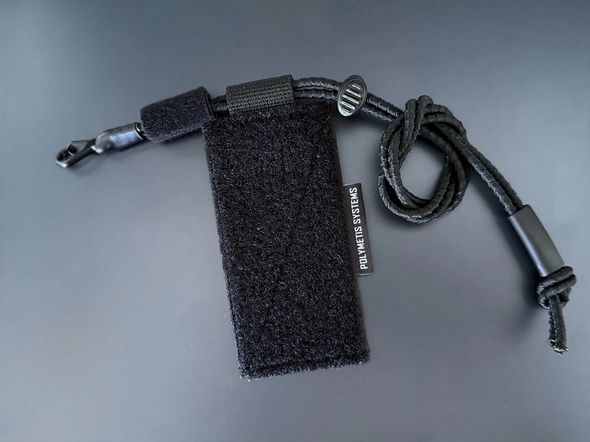 Essential Item Retention Panel EIRP from Polymetis Systems in Ranger Green. To lanyard any mission-critical equipment with metal karabiner and elastic shock cord on an Velcro Panel