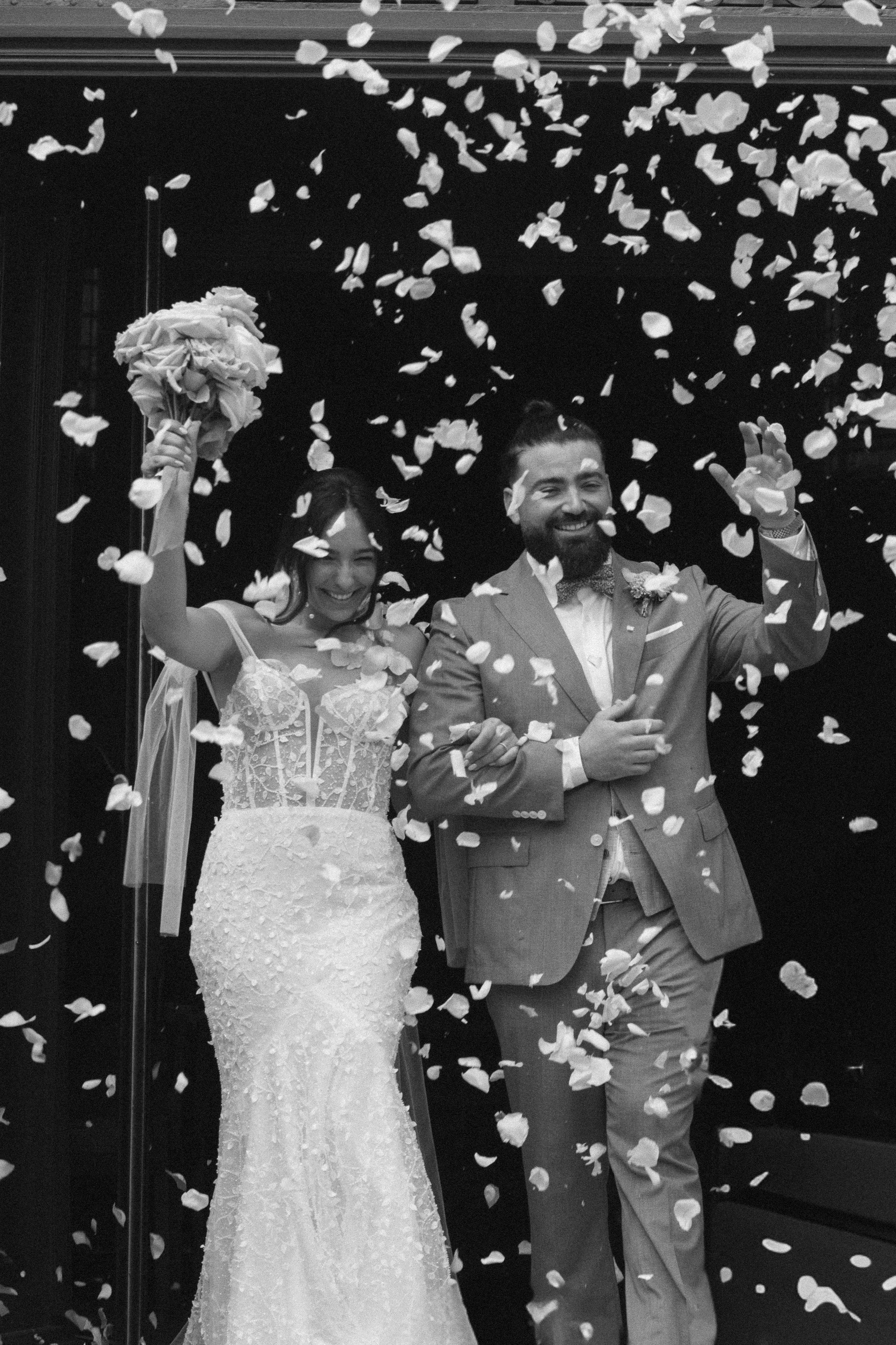 Mariage avec couple souriant, femmes en robe blanche et homme en costume, confettis tombant