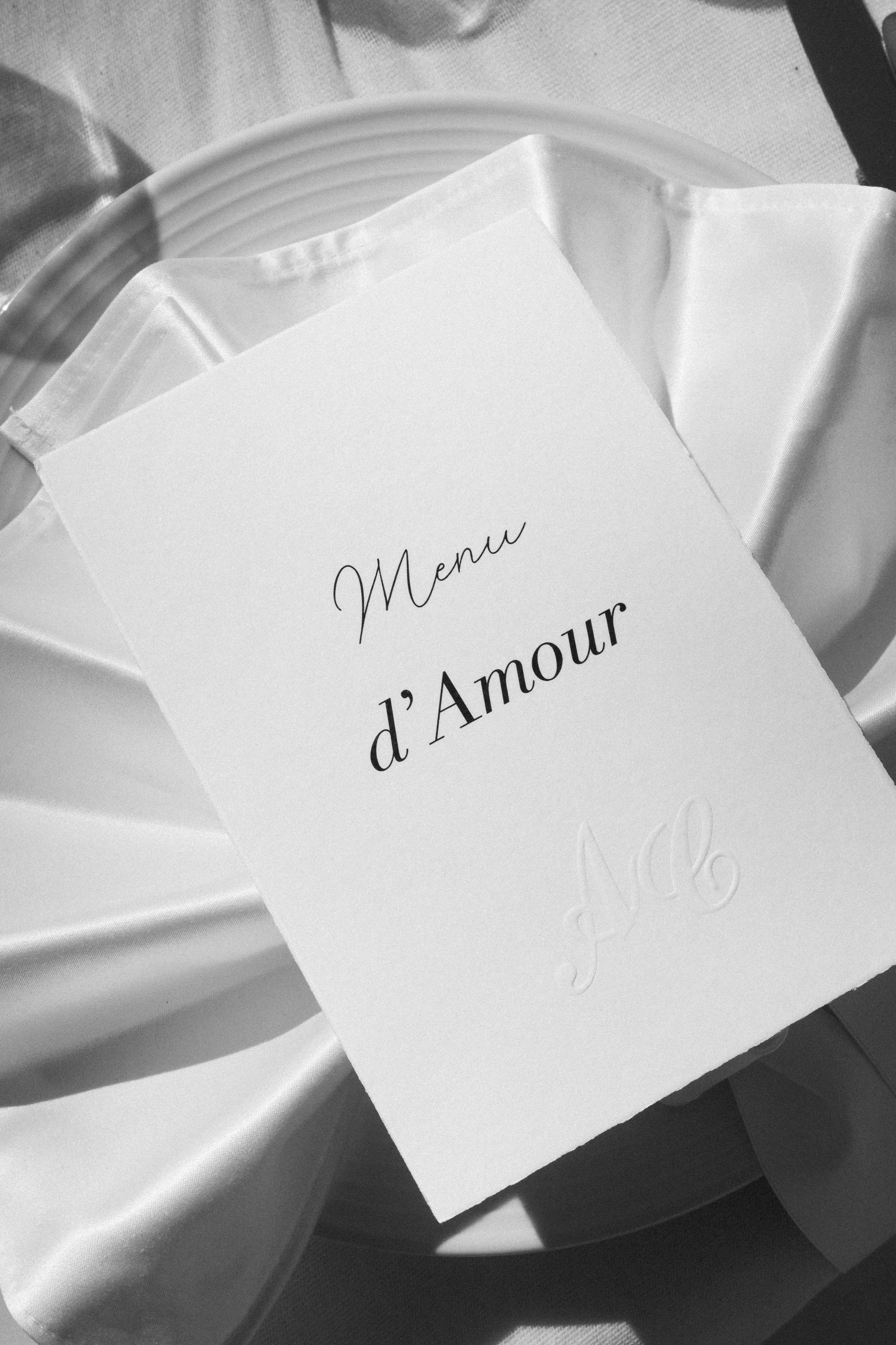 Carte de menu d'amour posée sur une assiette avec une nappe en satin.