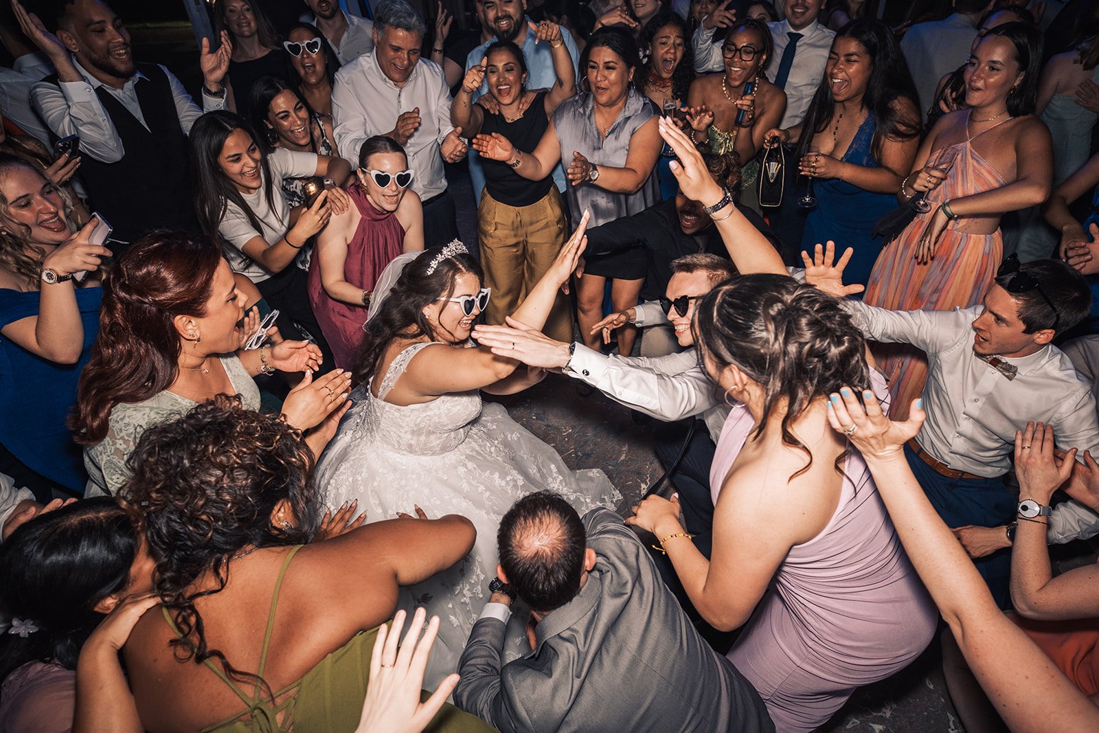 Mariés entourés de leurs invités en pleine fête sur la piste de danse — le genre de moment spontané et authentique que notre duo photo-vidéo capture sans en manquer une miette.