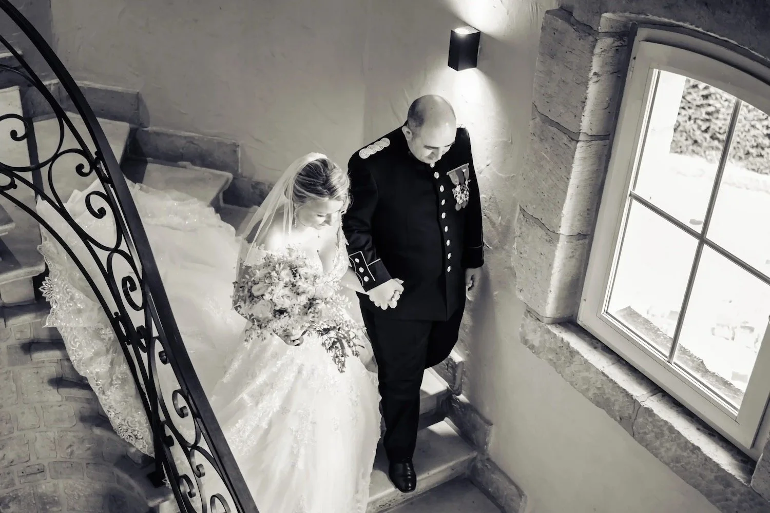 Reportage photo mariage en Belgique - mariés dans un escalier de château, À Tantôt Productions