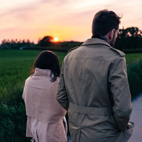 Couple dos à dos au coucher de soleil dans un champ — formule La Grande Traversée — À Tantôt Productions