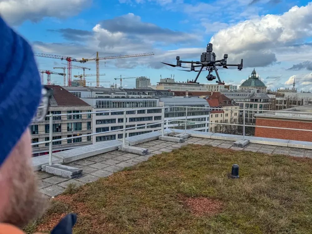 Inspektionsdrohne M300 RTK mit P1 auf Dach in München mit Frauenkirche im Hintergrund