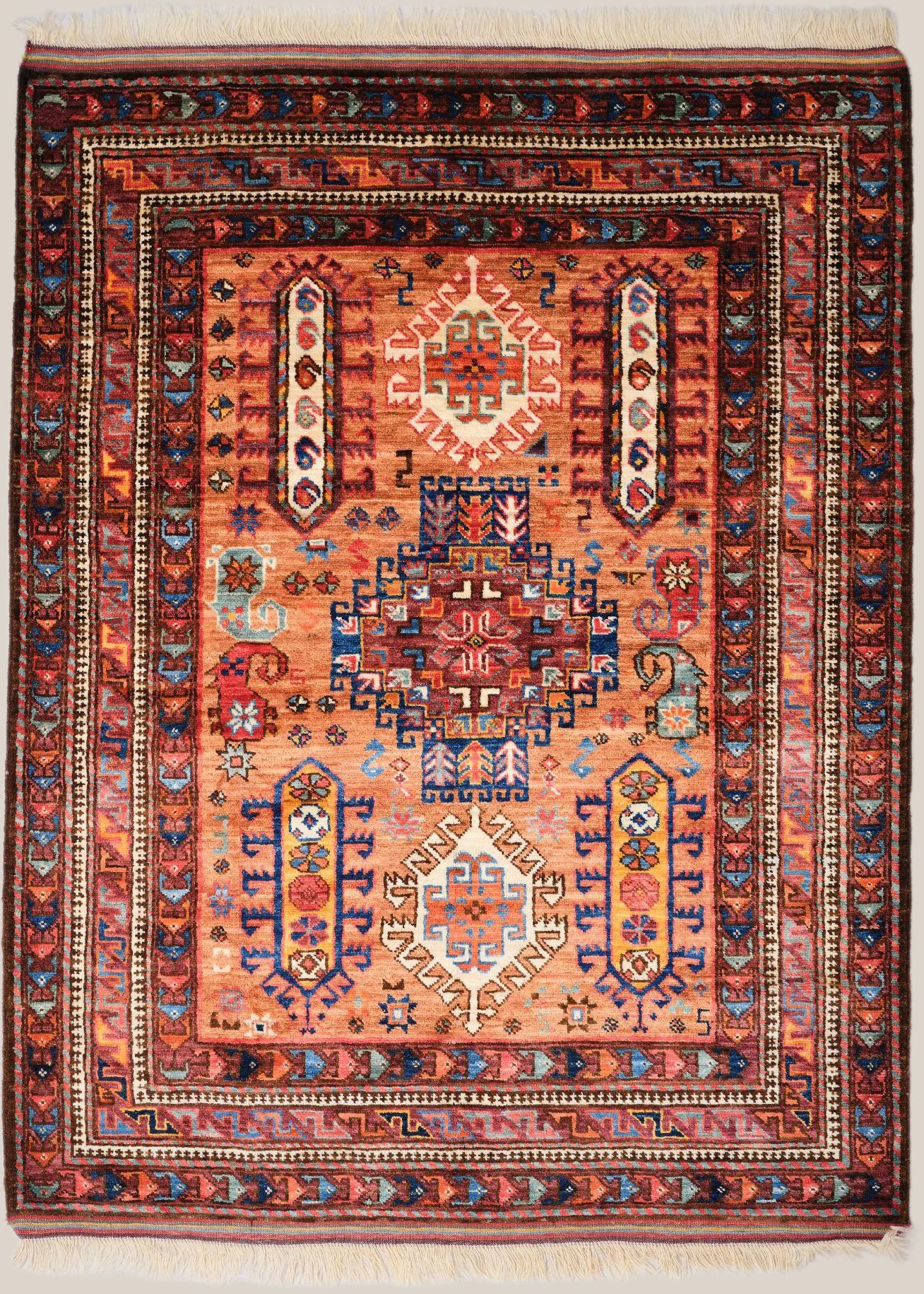 Traditional Persian-style rug with geometric patterns in red, blue, white, and orange tones, featuring intricate borders and central motifs.